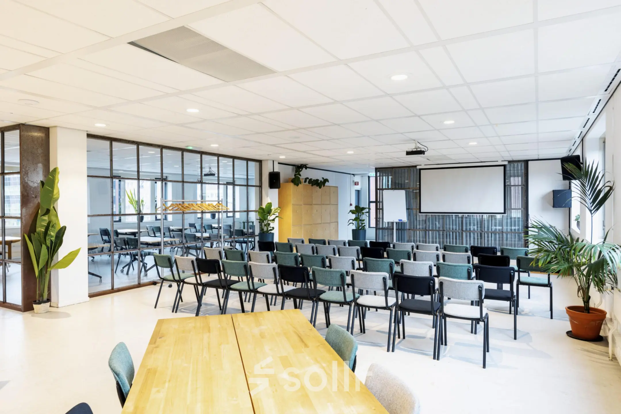 Furnished office space for rent at Hanzeplein 11-27, Zwolle, featuring rows of chairs facing a projection screen, ideal for conferences or presentations.