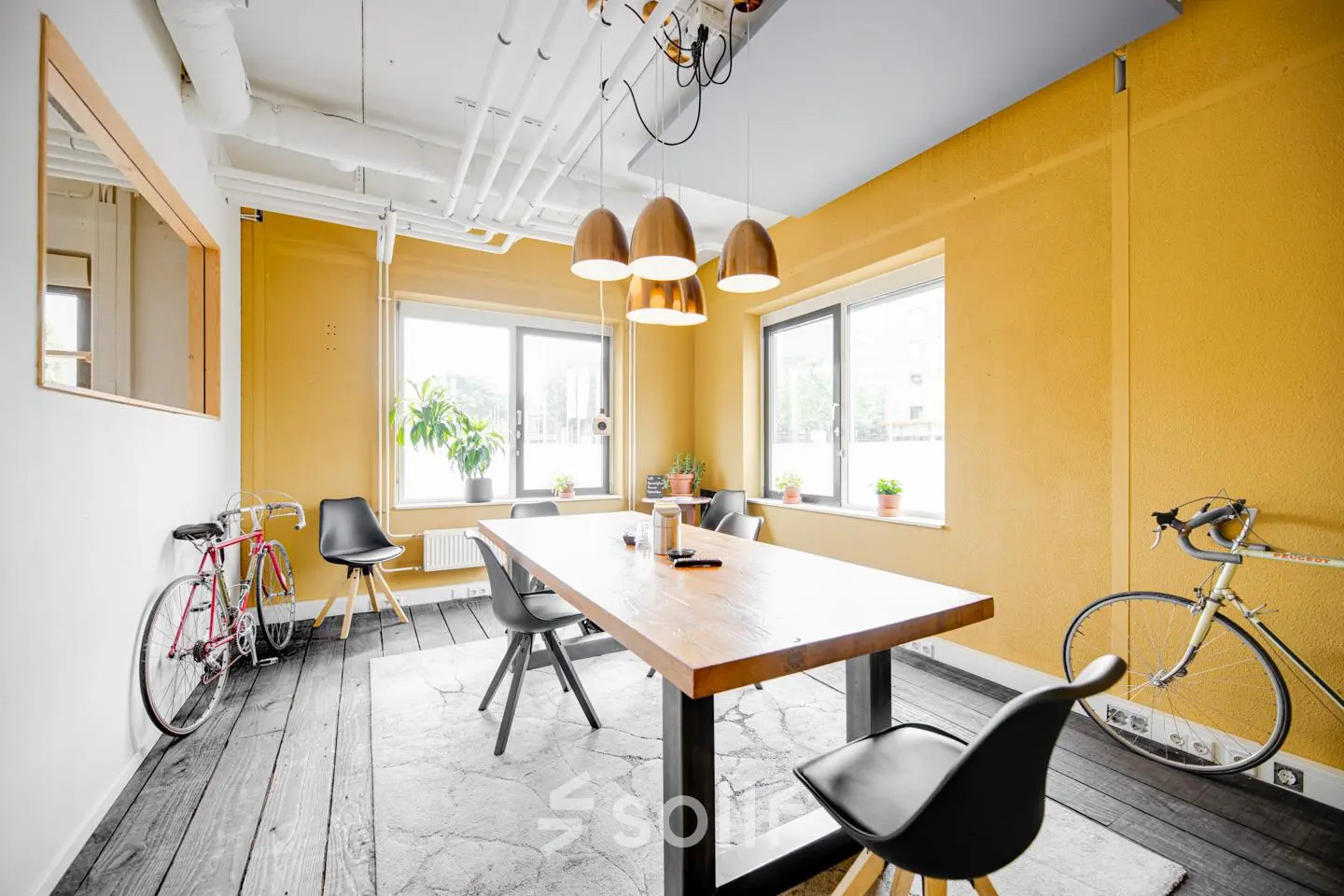 Bright office space at Hanzeplein 11-27, Zwolle with a wooden table, chairs, and decorative bicycles, ideal for office space rental.