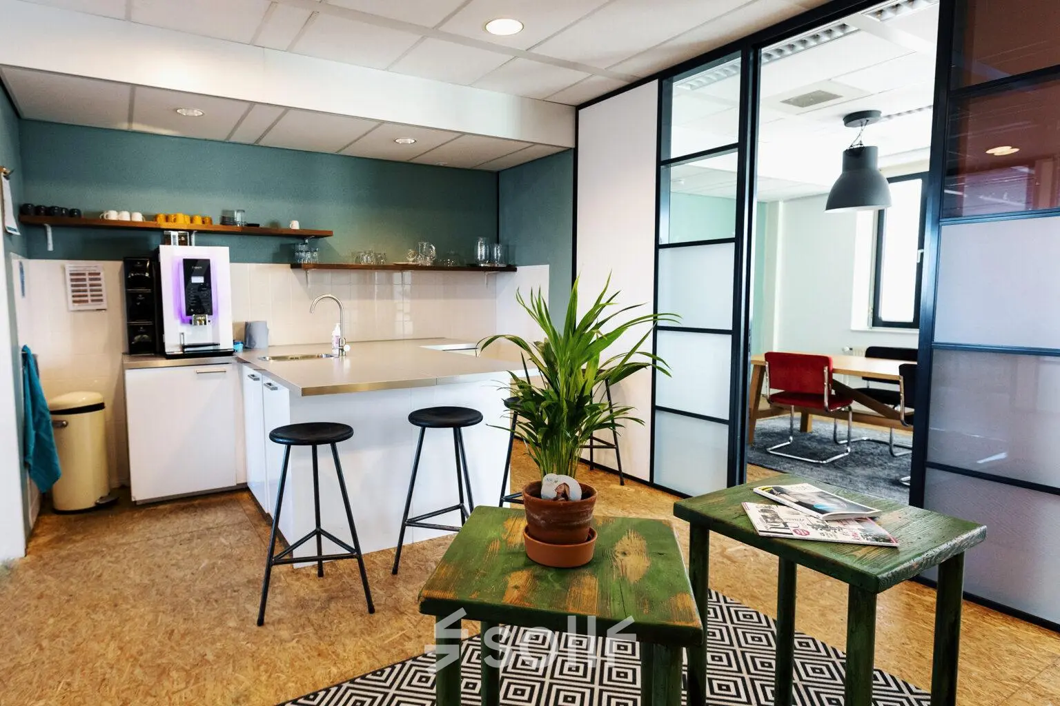 Modern office space available for rent at Hanzeplein 11-27, Zwolle. Features a furnished kitchenette with seating and a small lounge area, perfect for office space rental needs.