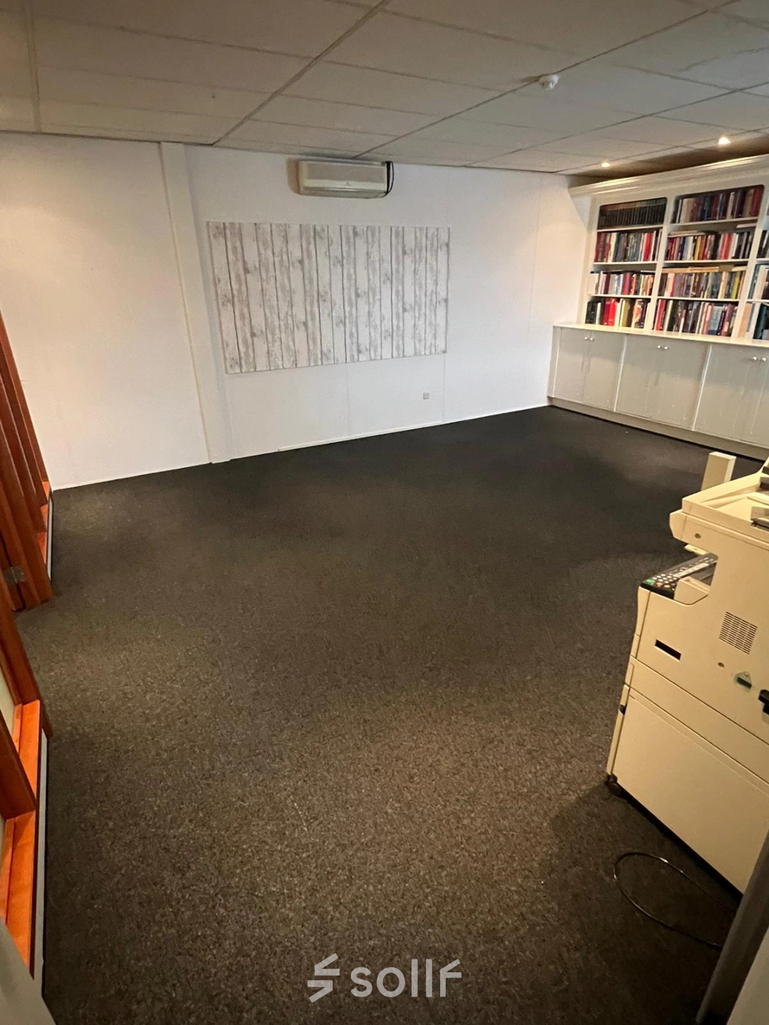 Spacious office at Pascalweg 6, Zwolle, featuring a carpeted floor, bookshelves, and light décor. Ideal for office space rental and flexible workspace needs.