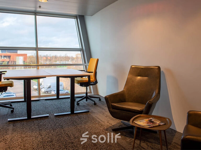 A furnished office space with chairs and desks by a large window at Zwartewaterallee 48, Zwolle, ideal for office space rental.