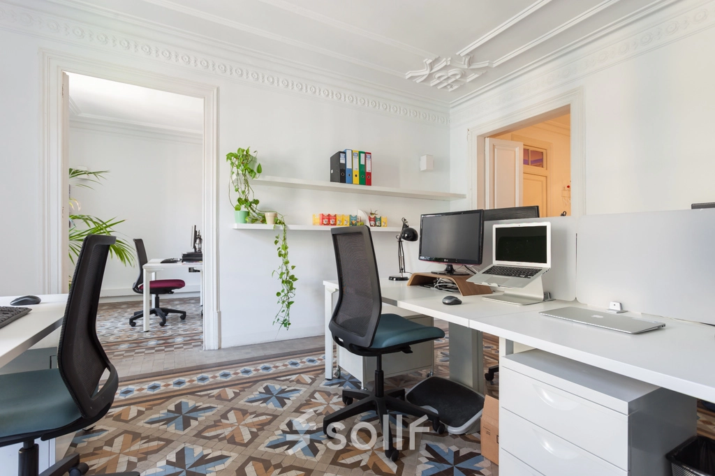 Oficina luminosa en alquiler de oficinas en Rambla de Catalunya 125, Barcelona Eixample, equipada con escritorios modernos y decoración elegante.
