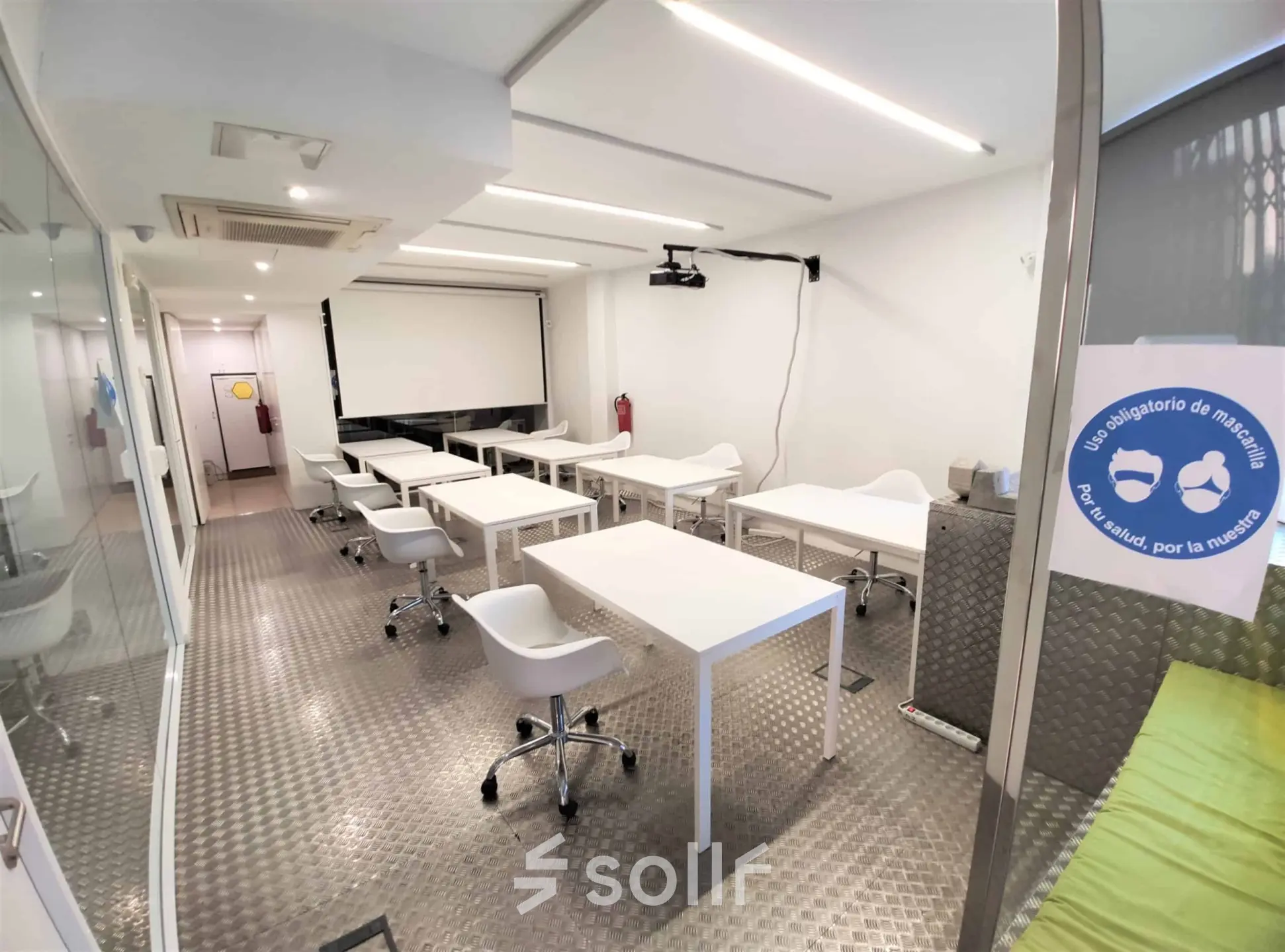 Espacio de oficina en Carrer Albigesos 25-27, Barcelona Gràcia con mesas blancas y sillas ergonómicas, ideal para alquilar una oficina.