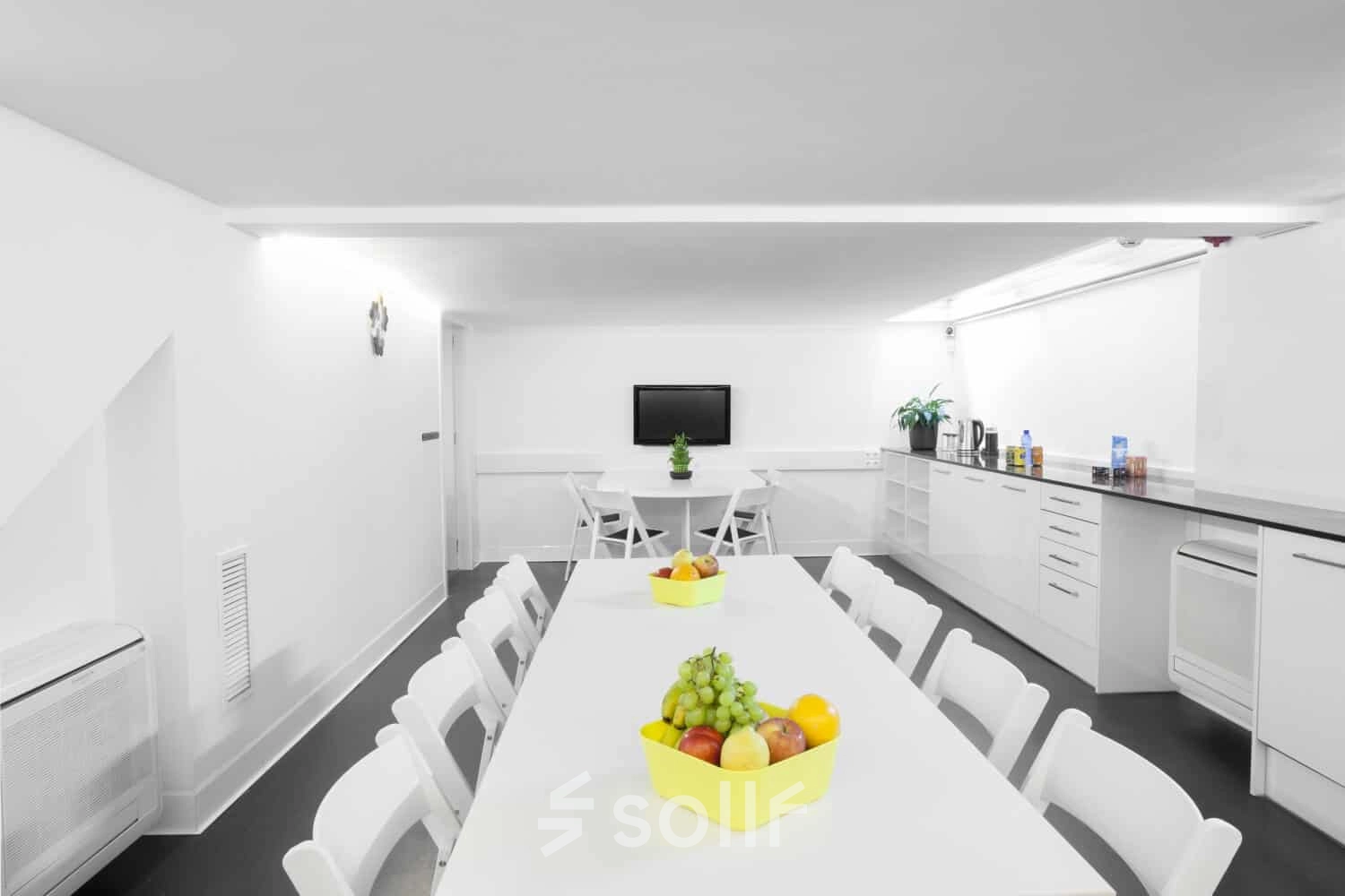 Espacio moderno y luminoso para alquilar una oficina en Carrer de L'Escorial 180, Barcelona Gràcia, con mesas blancas y detalles coloridos.