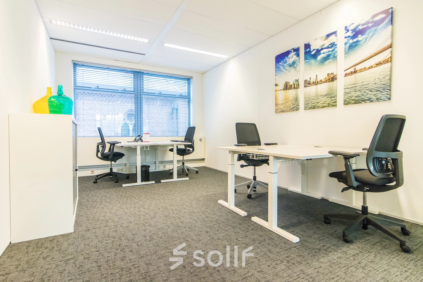 Espacio de alquiler de oficinas en Calle de Méndez Álvaro 20, Madrid Arganzuela, con dos escritorios, sillas y decoración moderna.