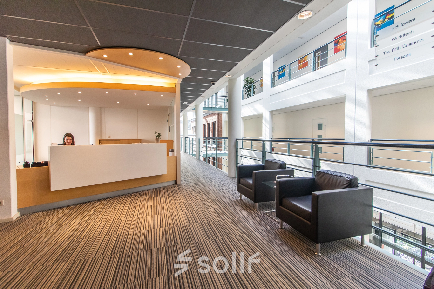 Recepción moderna en oficina de alquiler en Calle de Méndez Álvaro 20, Madrid Arganzuela, con diseño contemporáneo y sillones negros.