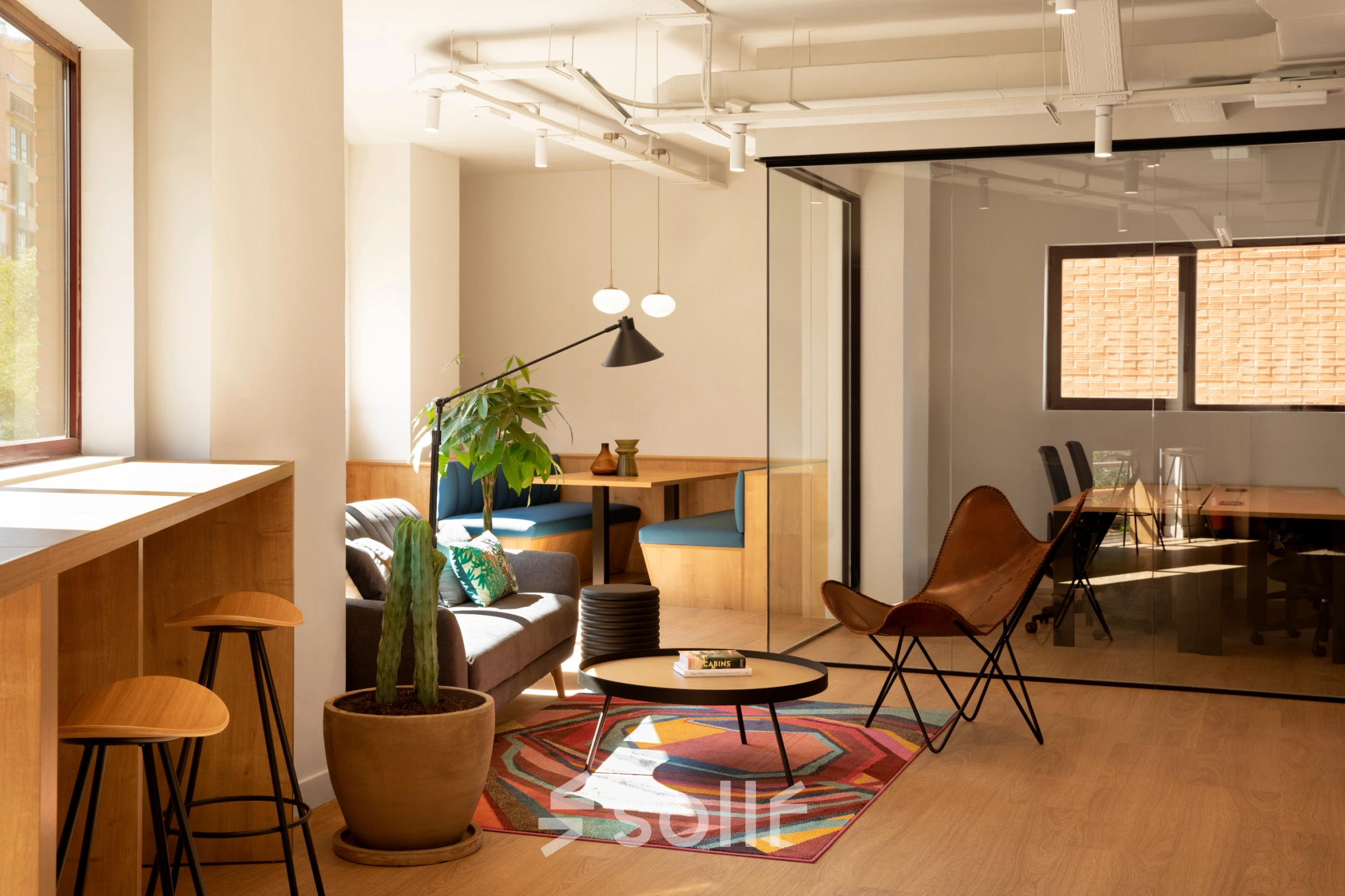Vista del área de descanso en alquiler de oficinas en Paseo Imperial 14, Madrid Centro, con sofás cómodos y una decoración moderna.