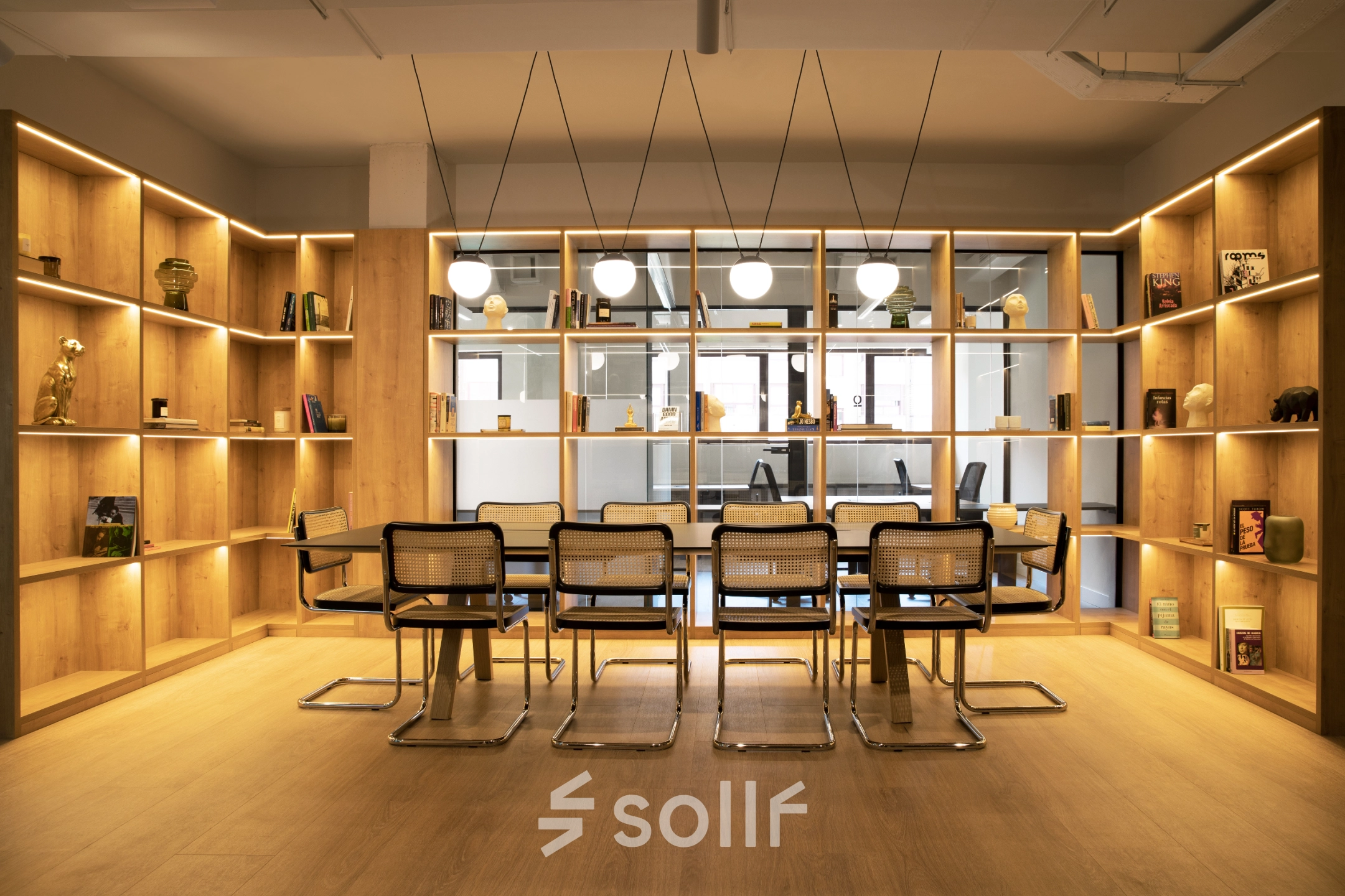 Espacio luminoso para alquilar una oficina en Paseo Imperial 14, Madrid Centro, con estanterías llenas y mobiliario moderno.