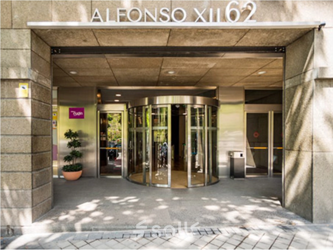 Entrada principal para alquilar una oficina en Calle de Alfonso XII 62, Madrid Retiro, con puerta giratoria y fachada elegante.