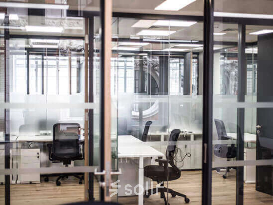 Espacio moderno y transparente ideal para alquilar una oficina en Calle de Alfonso XII 62, Madrid Retiro, con mesas y sillas ergonómicas.