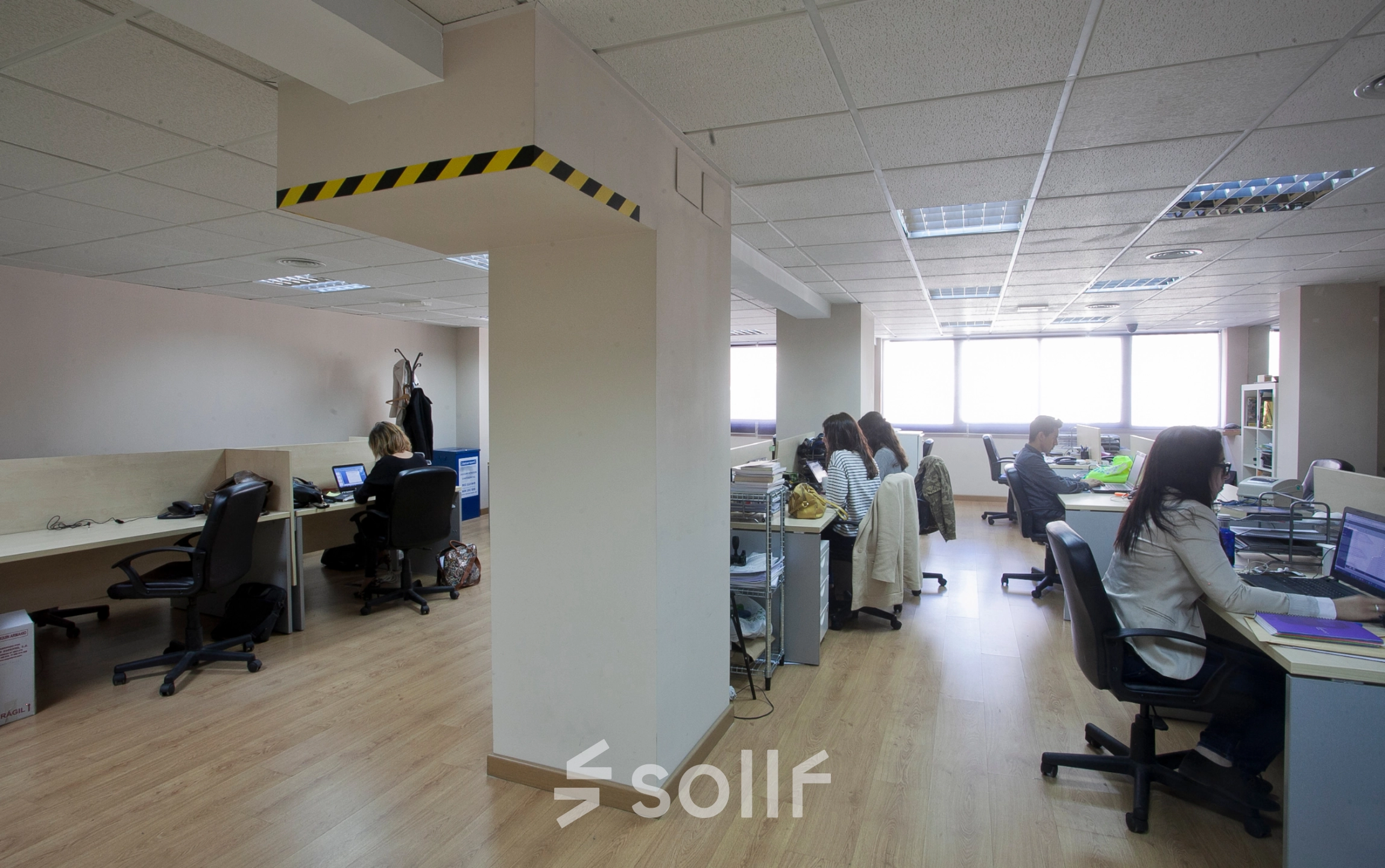 Oficina en Calle Lagasca 95, Madrid Salamanca, con empleados trabajando en sus escritorios. Espacio para alquilar una oficina con luz natural y suelo de madera.