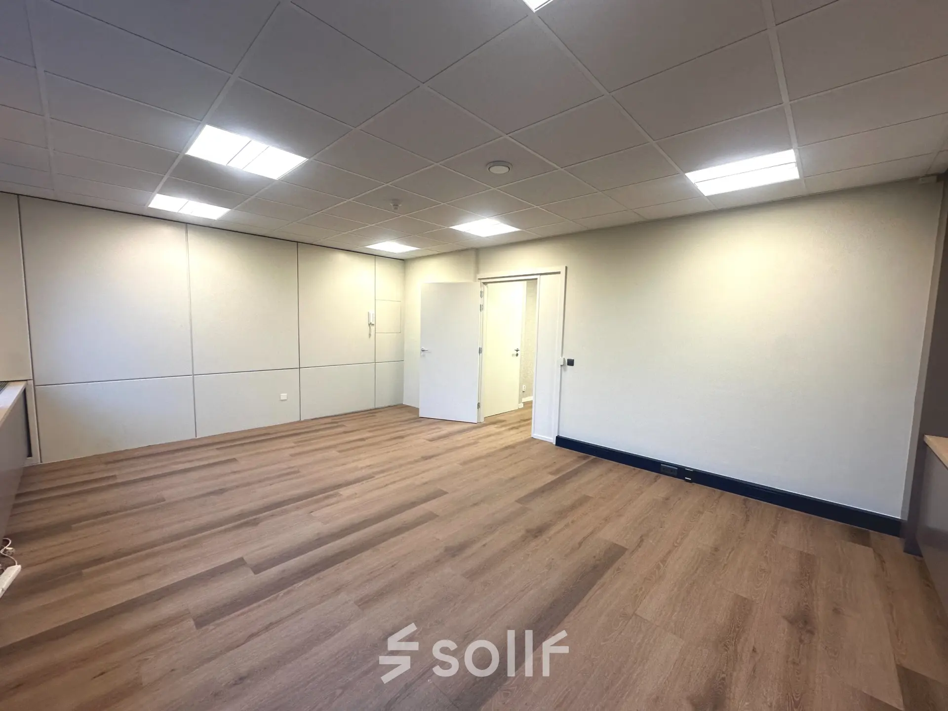 Lichte kantoorruimte op Hollandse Kade 38, Abcoude, met houten vloer en witte wanden, ideaal voor kantoorruimte huren. Voorzien van ingebouwde verlichting en meerdere deuren.