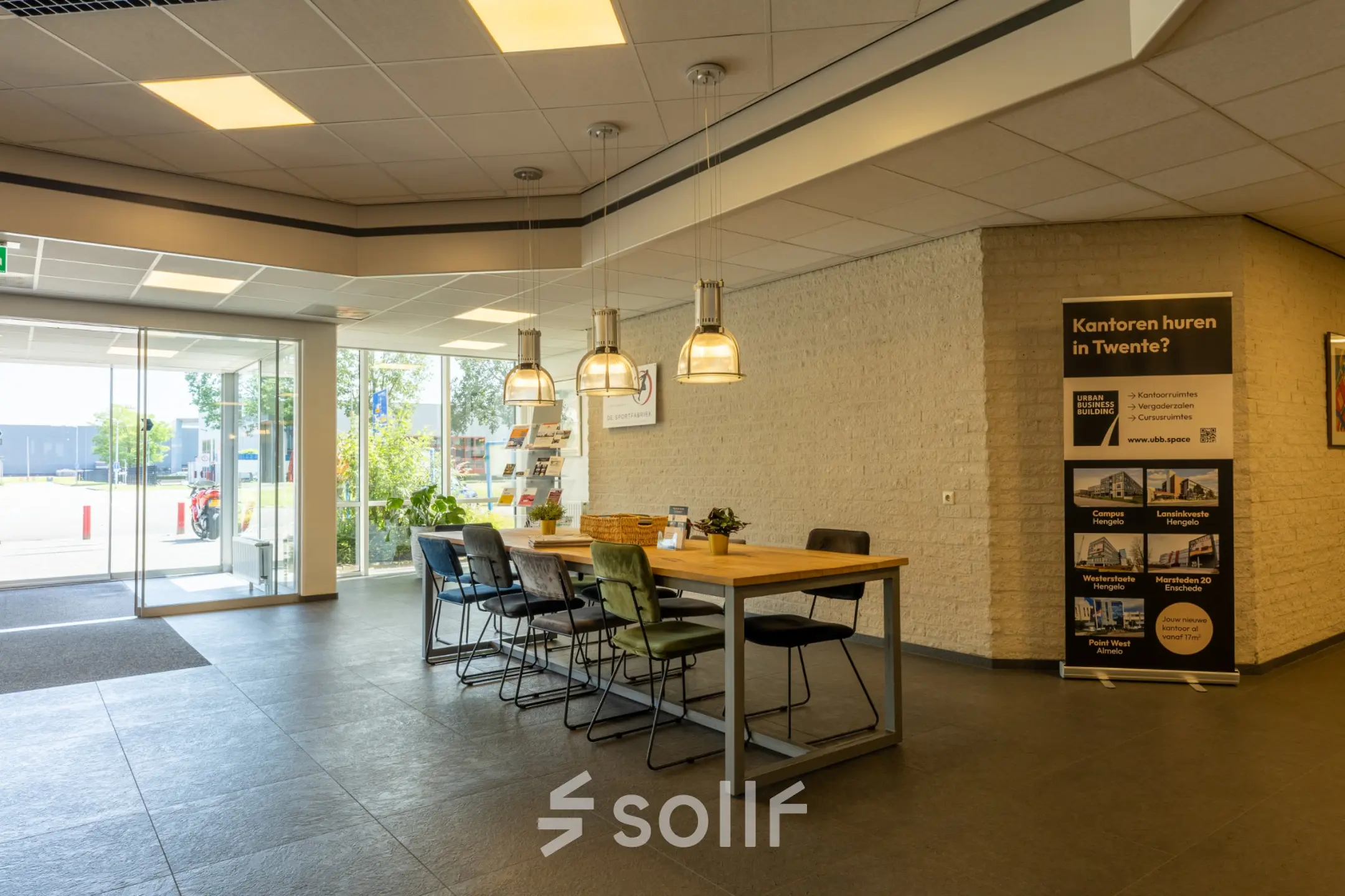 Inloop van een kantoorpand op Bedrijvenpark Twente 305 in Almelo met tafel en stoelen, geschikt voor huur van kantoorruimte.