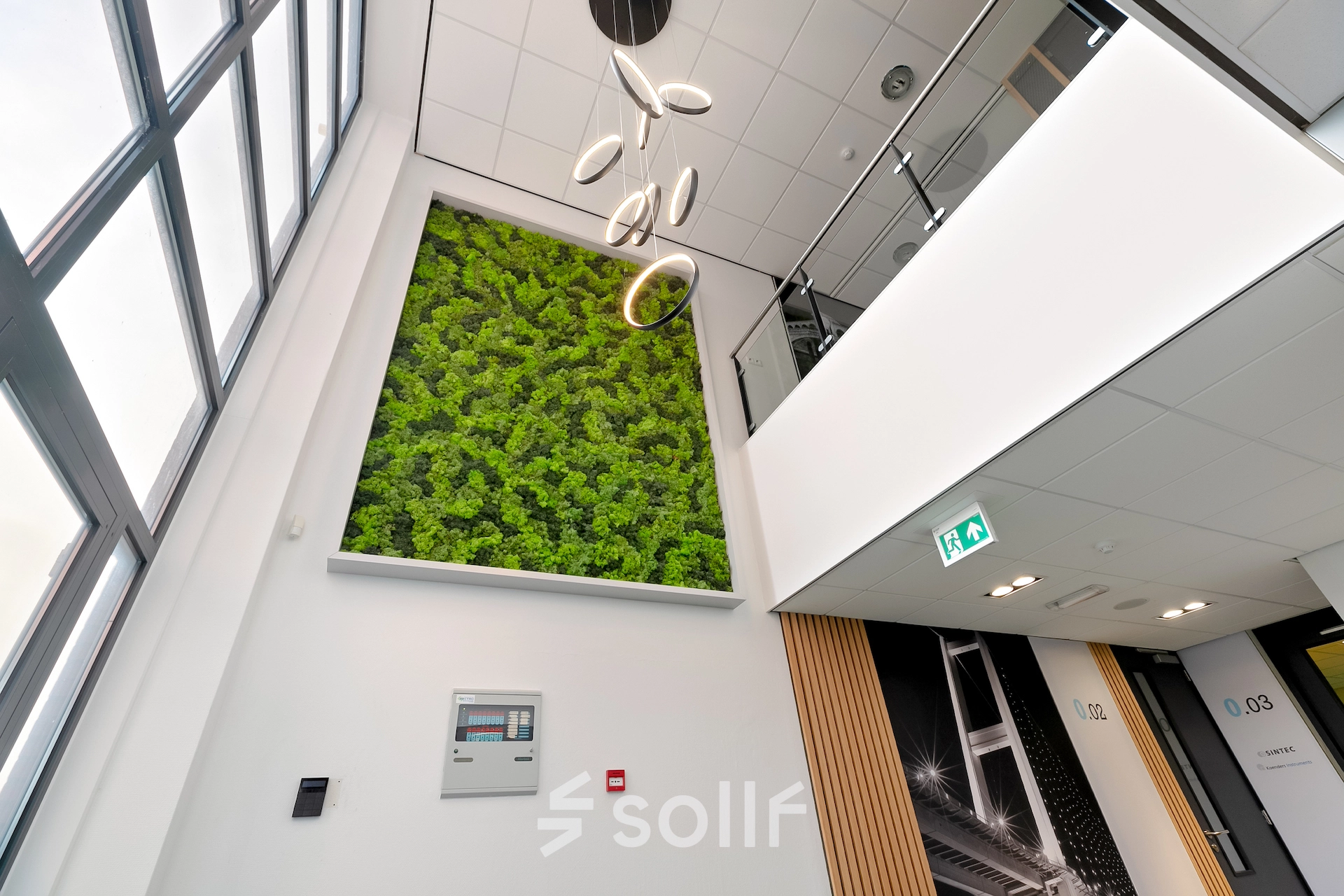 Ingang van een modern kantoorpand met een verticale tuin aan de muur in Almere Stad. Het interieur is licht en uitnodigend, ideaal voor bedrijven die kantoorruimte willen huren.