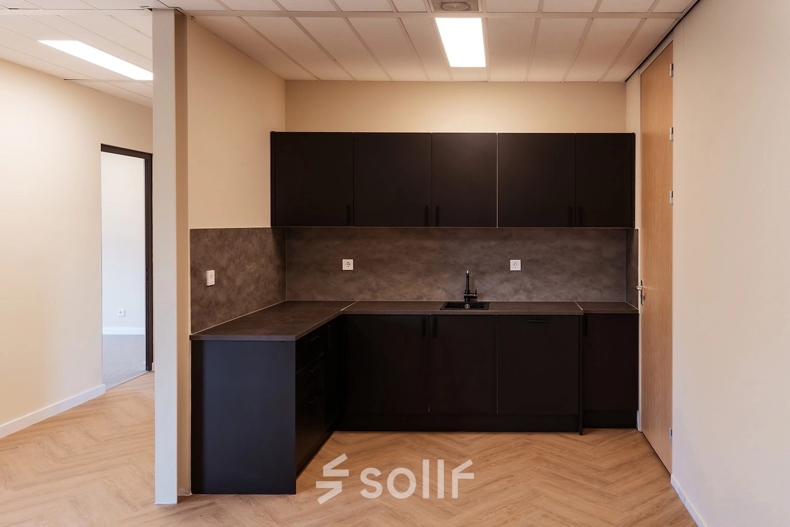 Moderne kantoorruimte te huur op Jool Hulstraat 2-14 in Almere Stad met minimalistisch keukenblok en neutrale kleuren.