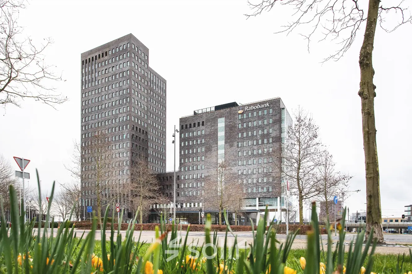 Kantoorpand aan de Landdrostdreef 124 in Almere Stad met moderne architectuur, omringd door groen en een open straat. Ideaal voor bedrijven die kantoorruimte willen huren in een levendige zakelijke omgeving.