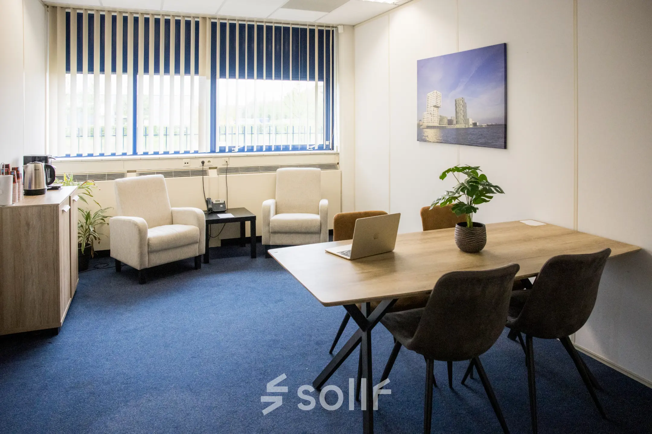 Kantoorruimte te huur op Markerkant 1310 in Almere Stad met een vergadertafel, stoelen, zithoek en een bloempot. Perfect voor een efficiënte werkdag.