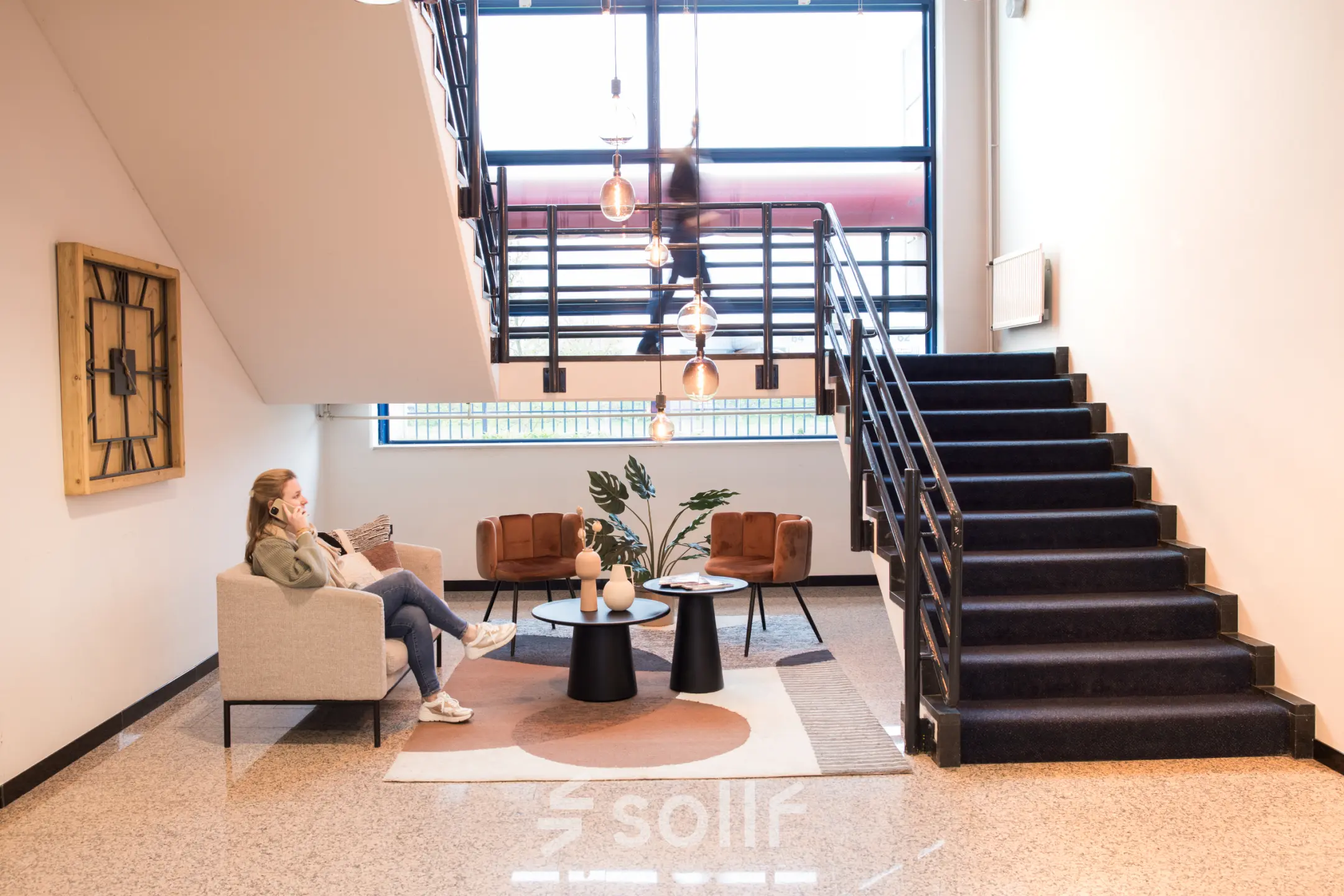 Moderne kantoren te huur op Markerkant 1310 in Almere Stad; lichte entree met comfortabele meubels en een stijlvolle trap.