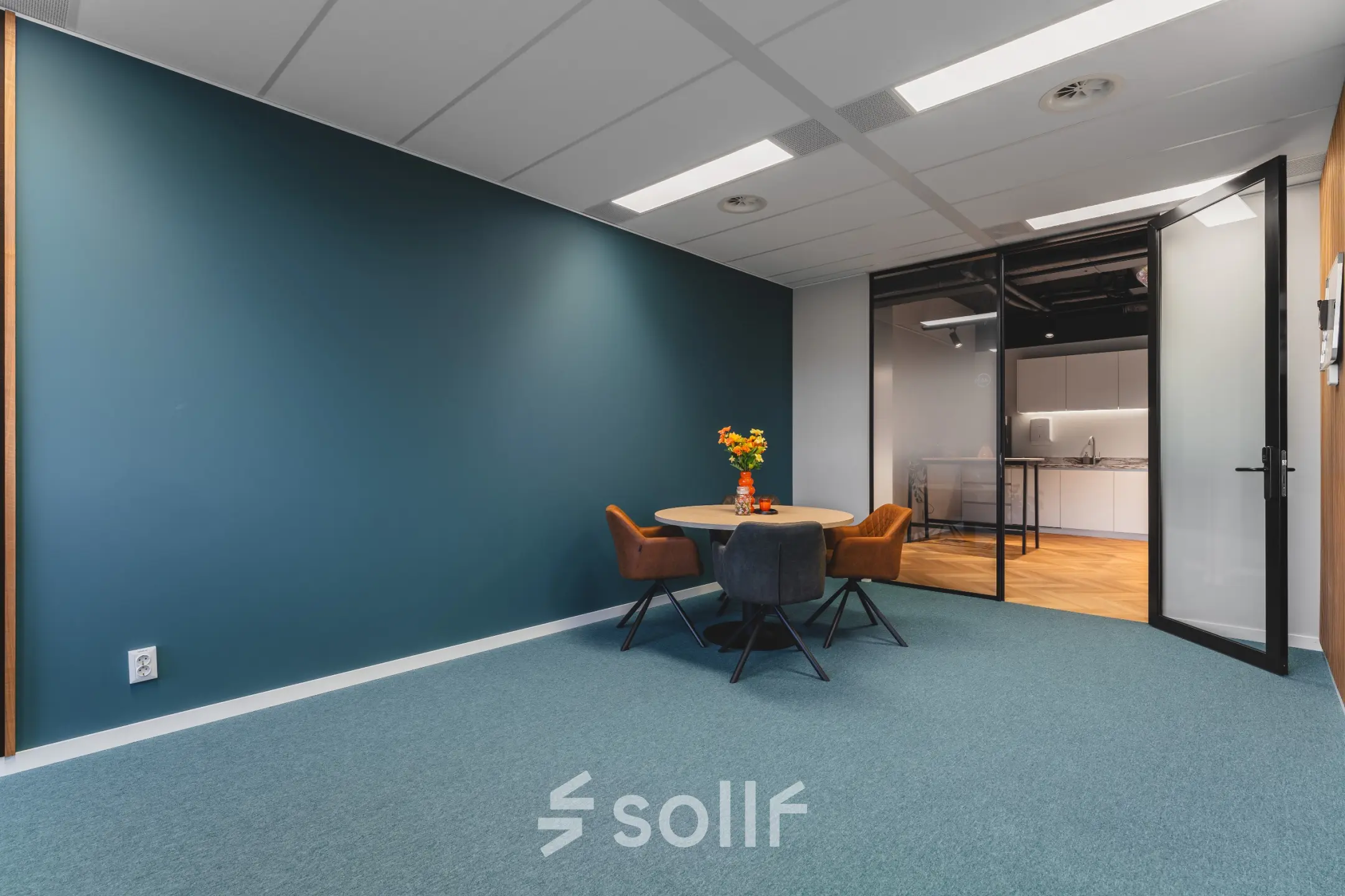 Moderne kantoorruimte te huur op Veluwezoom 15 in Almere Stad, met een tafel en stoelen. Het kantoor heeft een strak, minimalistisch design en is ideaal voor vergaderingen of werkontmoetingen.