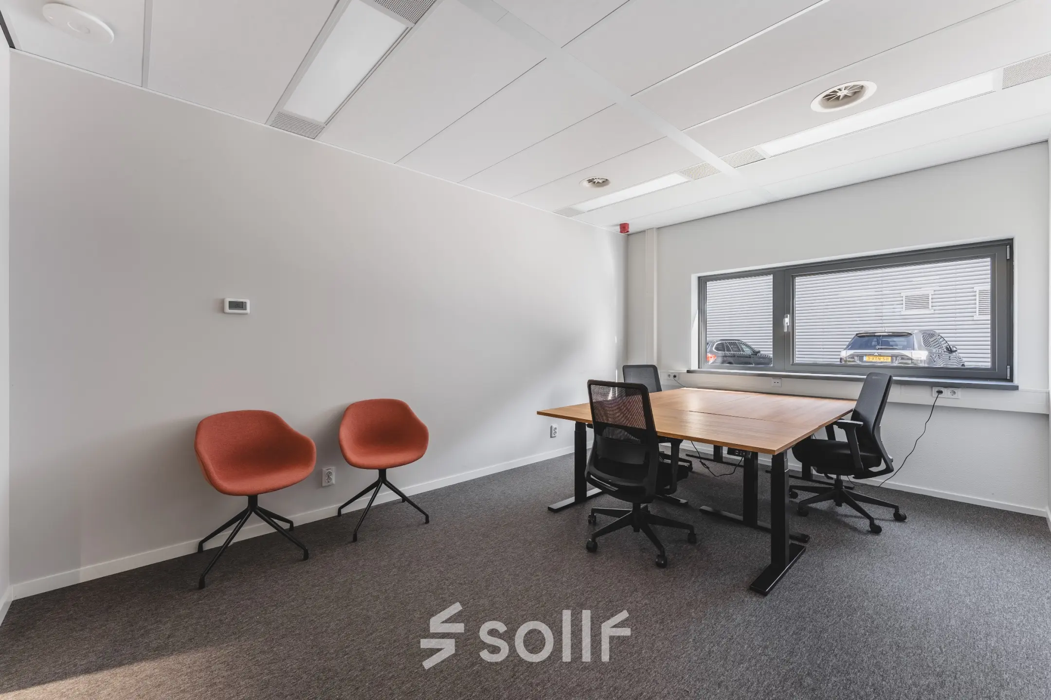 Kantoorruimte huren aan Veluwezoom 15 in Almere Stad met strak bureau en moderne stoelen, gelegen in een lichte ruimte met groot raam.
