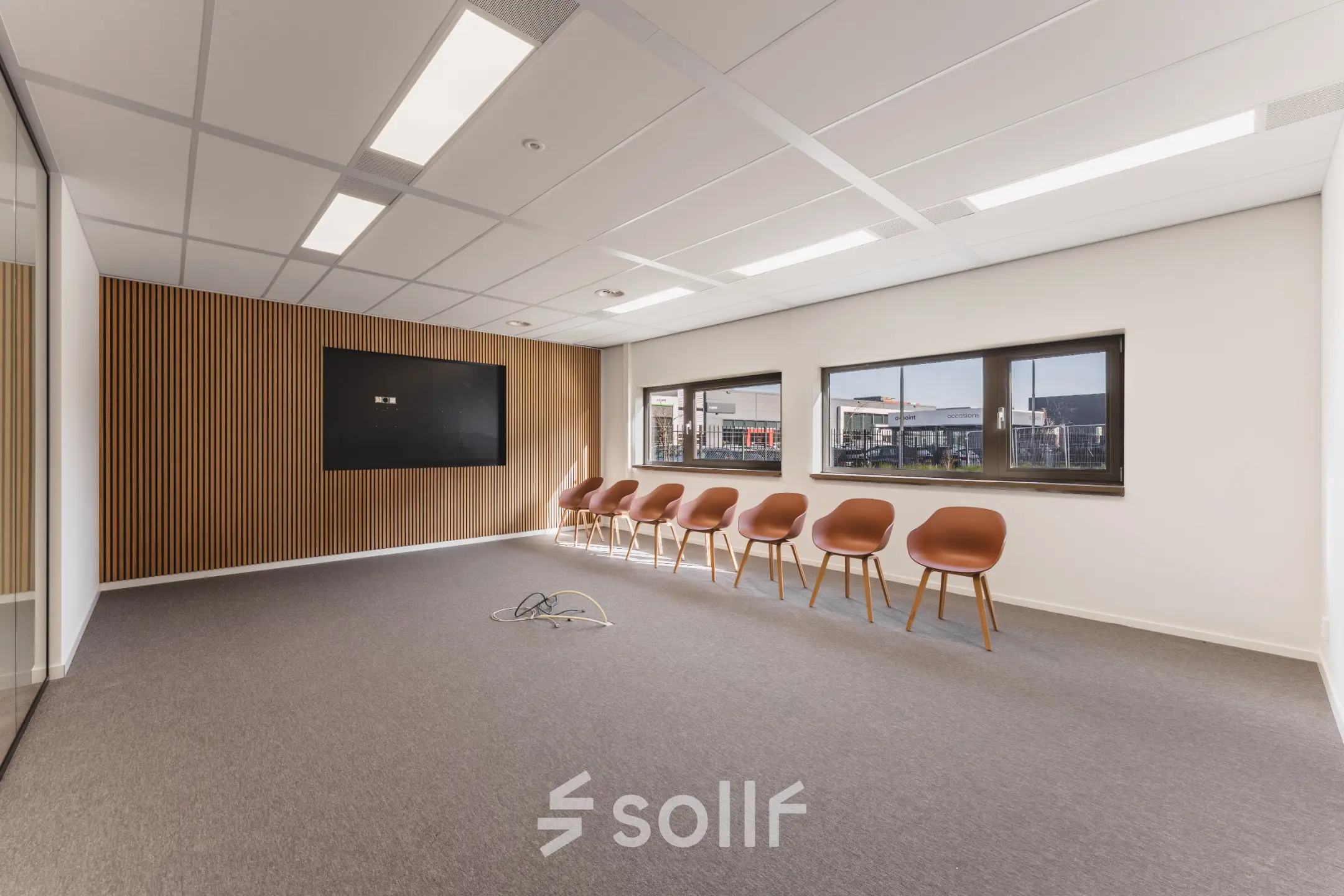 Moderne kantoorruimte op Veluwezoom 15 in Almere Stad met strakke lijnen, houten accenten en een rij stijlvolle stoelen langs de muur. Klaar voor vergaderingen of flexibele werkplekken.