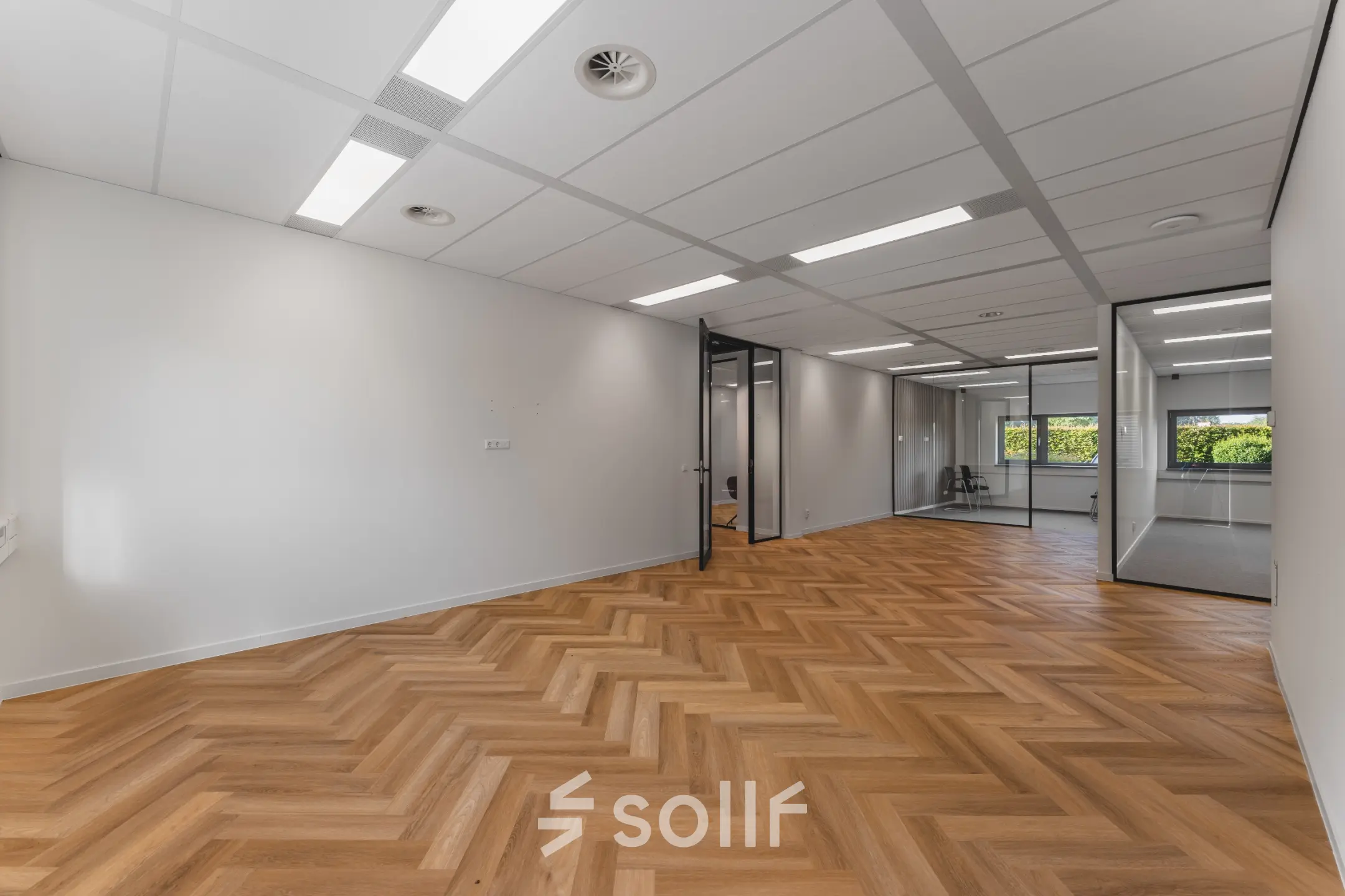 Moderne kantoorruimte op Veluwezoom 15 in Almere Stad met houten vloer en glazen tussenwanden. Ideaal om te huren voor een professionele werkomgeving.