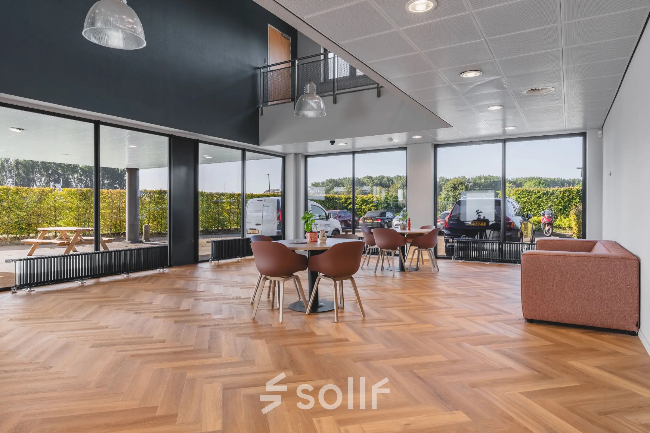 Lichte kantoorruimte met grote ramen en een parketvloer, ingericht met tafels en stoelen op Veluwezoom 15, Almere Stad. Ideaal voor wie kantoorruimte wil huren in een inspirerende omgeving.