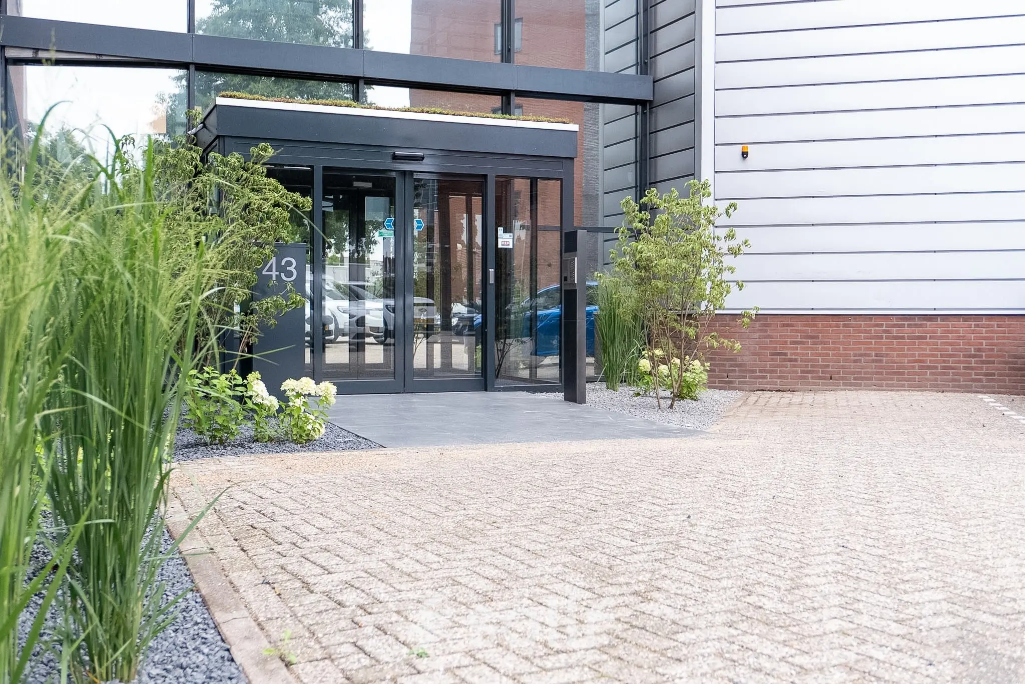 De ingang van een modern kantoorpand op Maanlander 43 in Amersfoort, ideaal voor wie kantoorruimte wil huren.