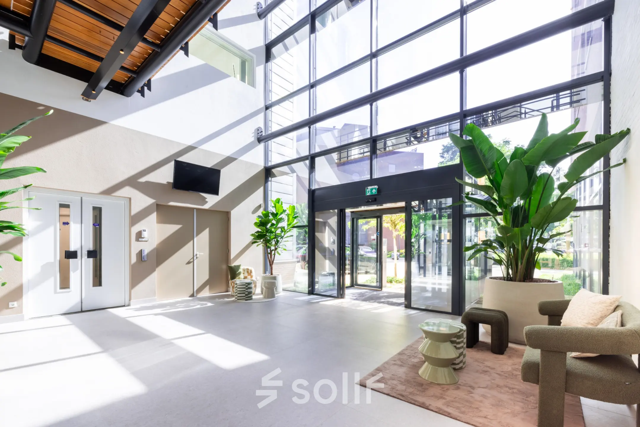 Heldere en moderne ontvangstruimte met grote ramen, planten en stijlvolle meubels. Ideaal voor kantoorruimte huren in Amersfoort Calveen.