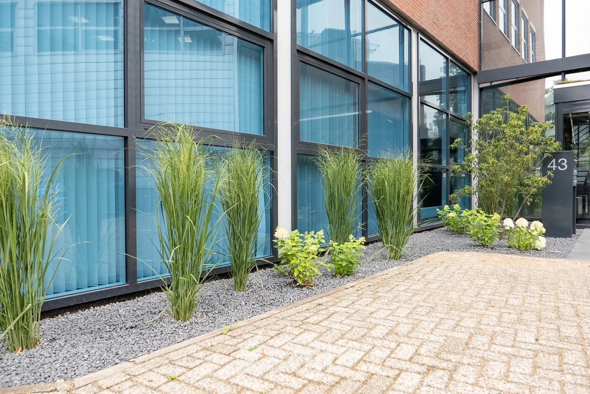 Exterieur van een modern kantoorpand op Maanlander 43 in Amersfoort Calveen, met goed onderhouden groenvoorzieningen voor de ramen. Ideaal voor wie kantoorruimte wil huren in een zakelijke omgeving.