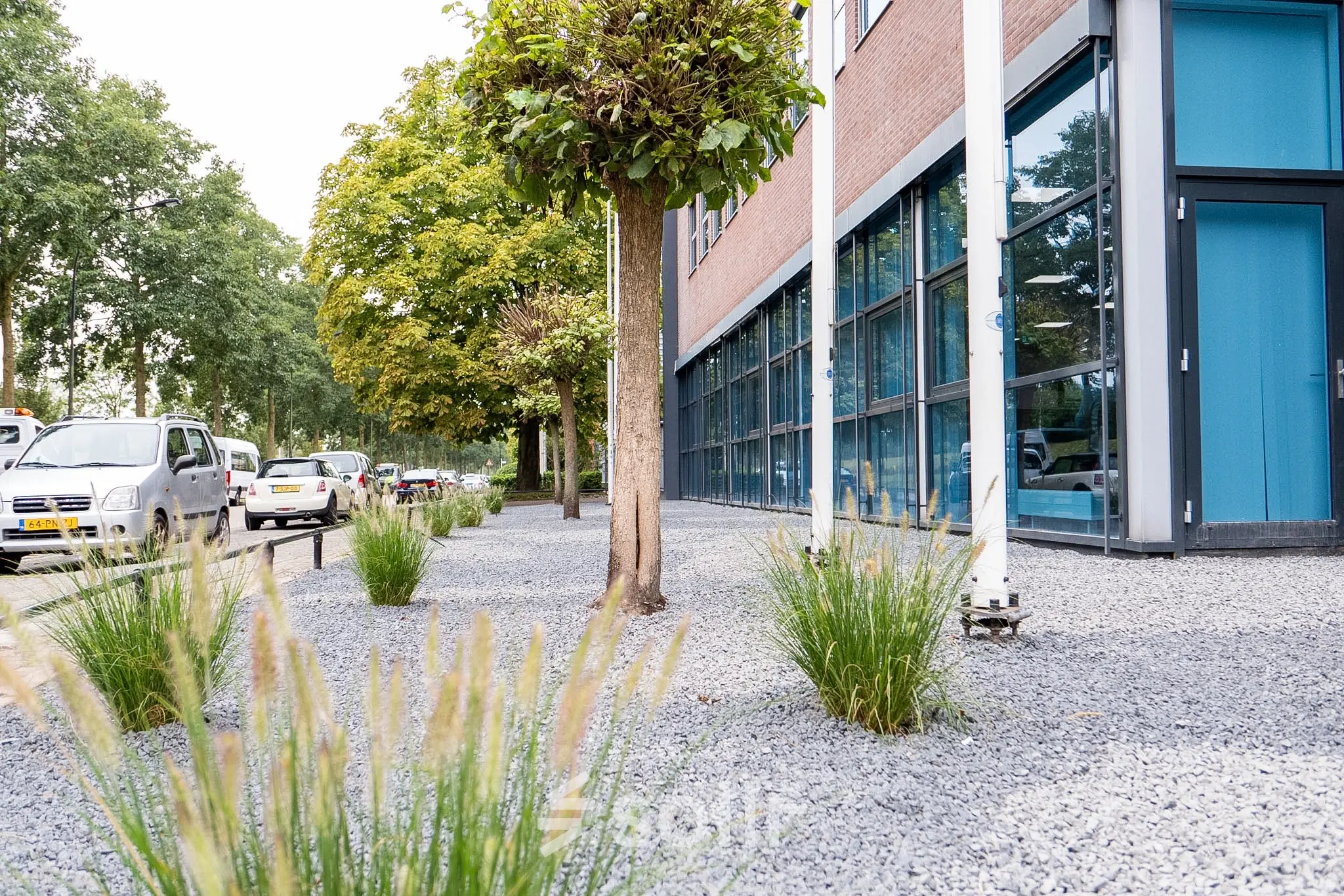 Buitenzijde van een modern kantoorpand op Maanlander 43 in Amersfoort Calveen, met goed onderhouden groen en grote glazen ramen. Geschikt om een kantoorruimte te huren.