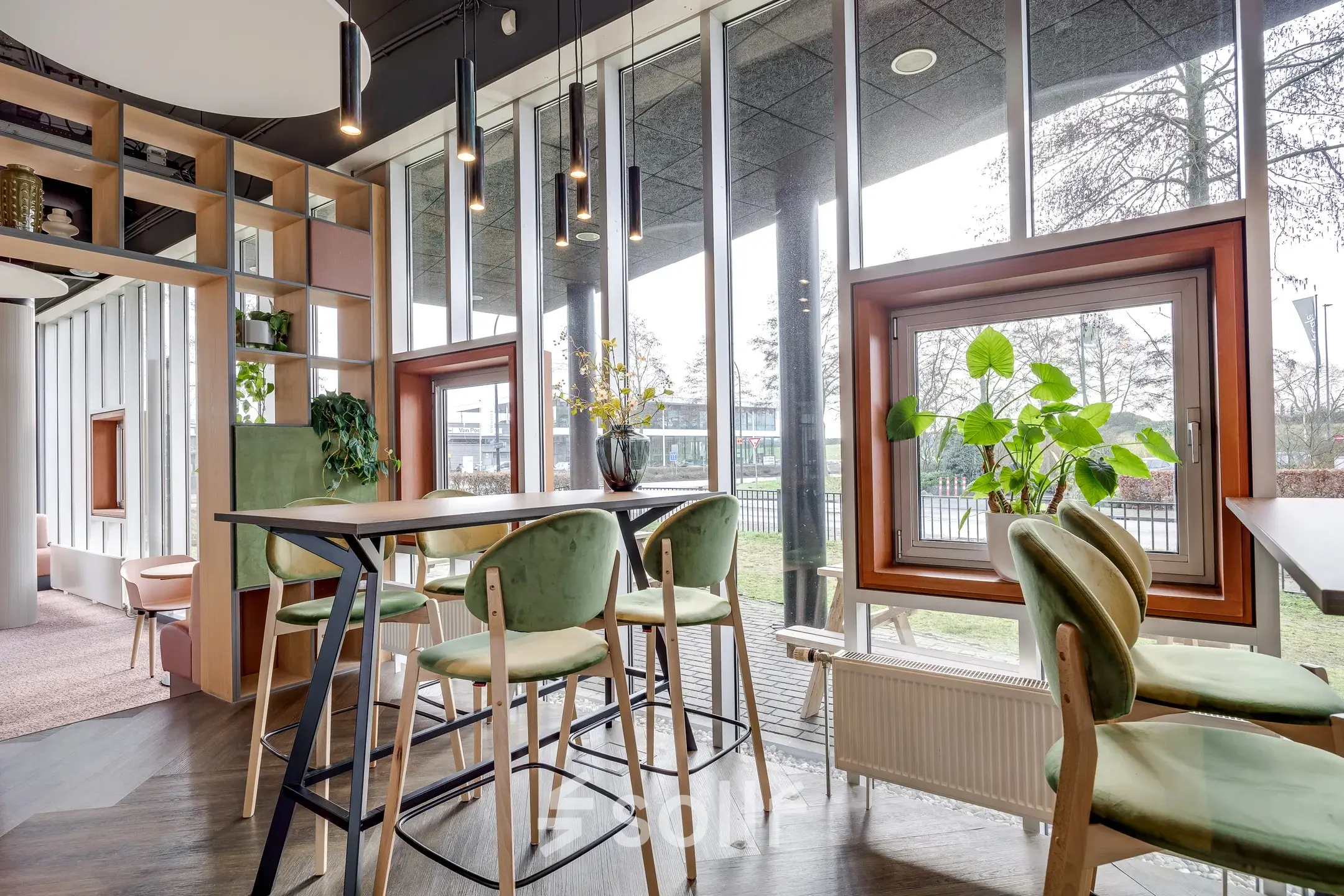 Moderne kantoorruimte huren in kantoorpand Maanlander 47, Amersfoort Calveen. Grote ramen laten veel licht binnen, met groen en hoge tafels in een uitnodigende omgeving.