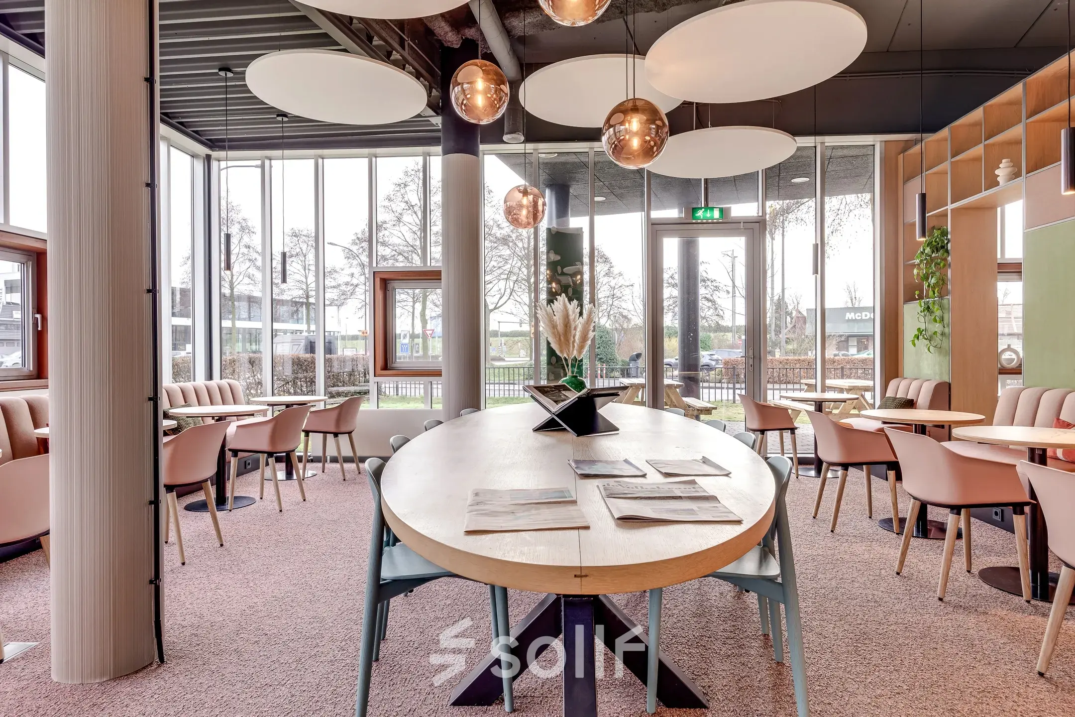 Moderne kantoorruimte met grote ovale tafel, lichte stoelen en decoratieve verlichting op Maanlander 47, Amersfoort Calveen. Ideaal voor vergaderingen of teamwork in een aantrekkelijk ingerichte werkomgeving.