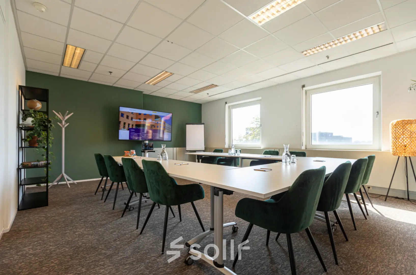 Vergaderzaal in kantoorpand op Stationsplein 49, Amersfoort Centraal Station met groene stoelen en conferentietafel. Ideaal voor kantoorruimte huren in een centraal gelegen kantoor.