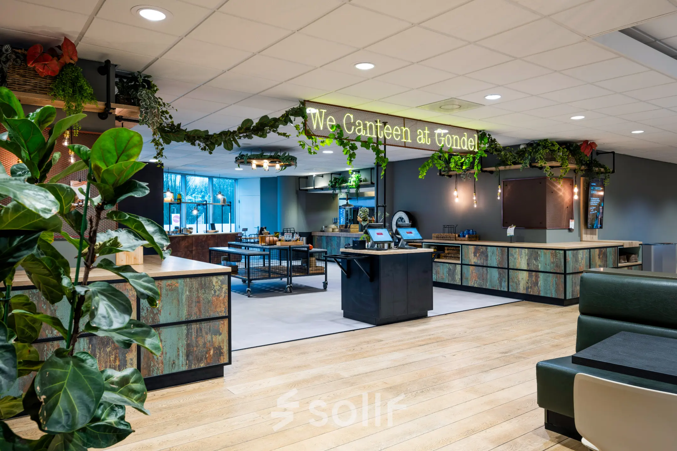Kantoorruimte huren op De Gondel 1 in Amstelveen. Moderne kantine met veel groen, houten details en zitplaatsen. Geschikt voor informele bijeenkomsten en lunchpauzes.