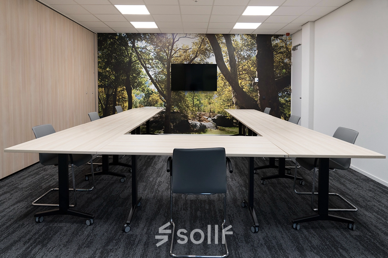 Kantoorpand Handelsweg 53 in Amstelveen, professionele vergaderruimte met een serene bosachtergrond, moderne tafels en stoelen, ideaal voor vergaderingen of presentaties. Perfect voor wie kantoorruimte wil huren.