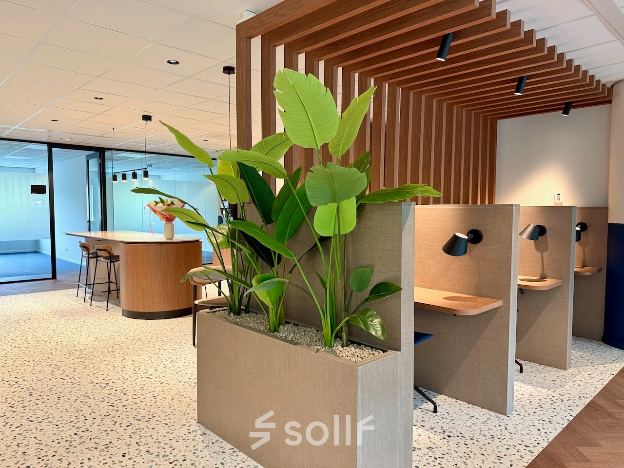 Moderne kantoorpand op Professor E.M. Meijerslaan 1 in Amstelveen, voorzien van groene planten en stijlvolle werkplekken met bureaus en lampen, ideaal voor kantoorruimte huren.