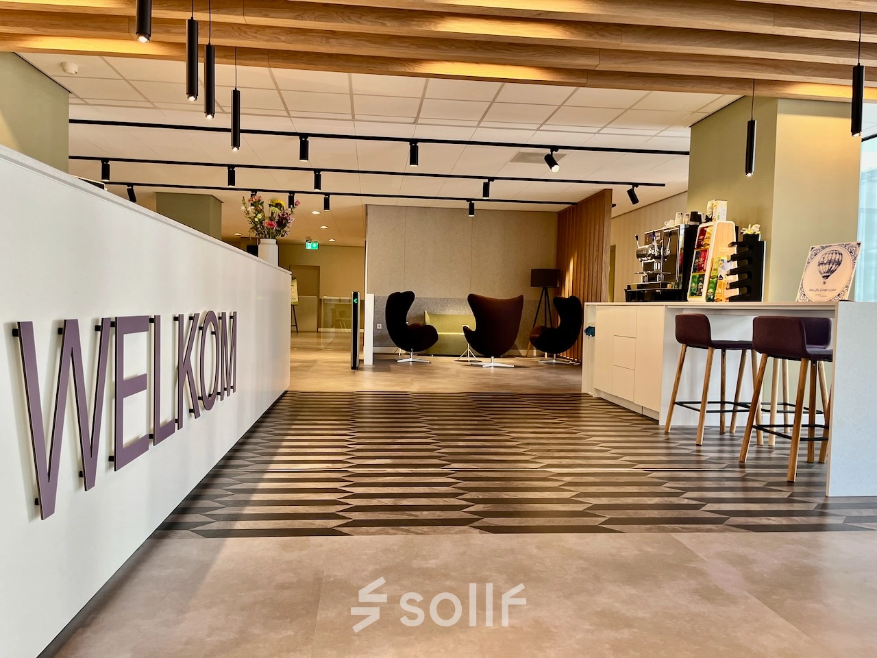Moderne entree van een kantoorpand op Professor E.M. Meijerslaan 1 in Amstelveen. Het interieur is strak met een welkom bord en stijlvolle meubels, ideaal om als kantoorruimte te huren.