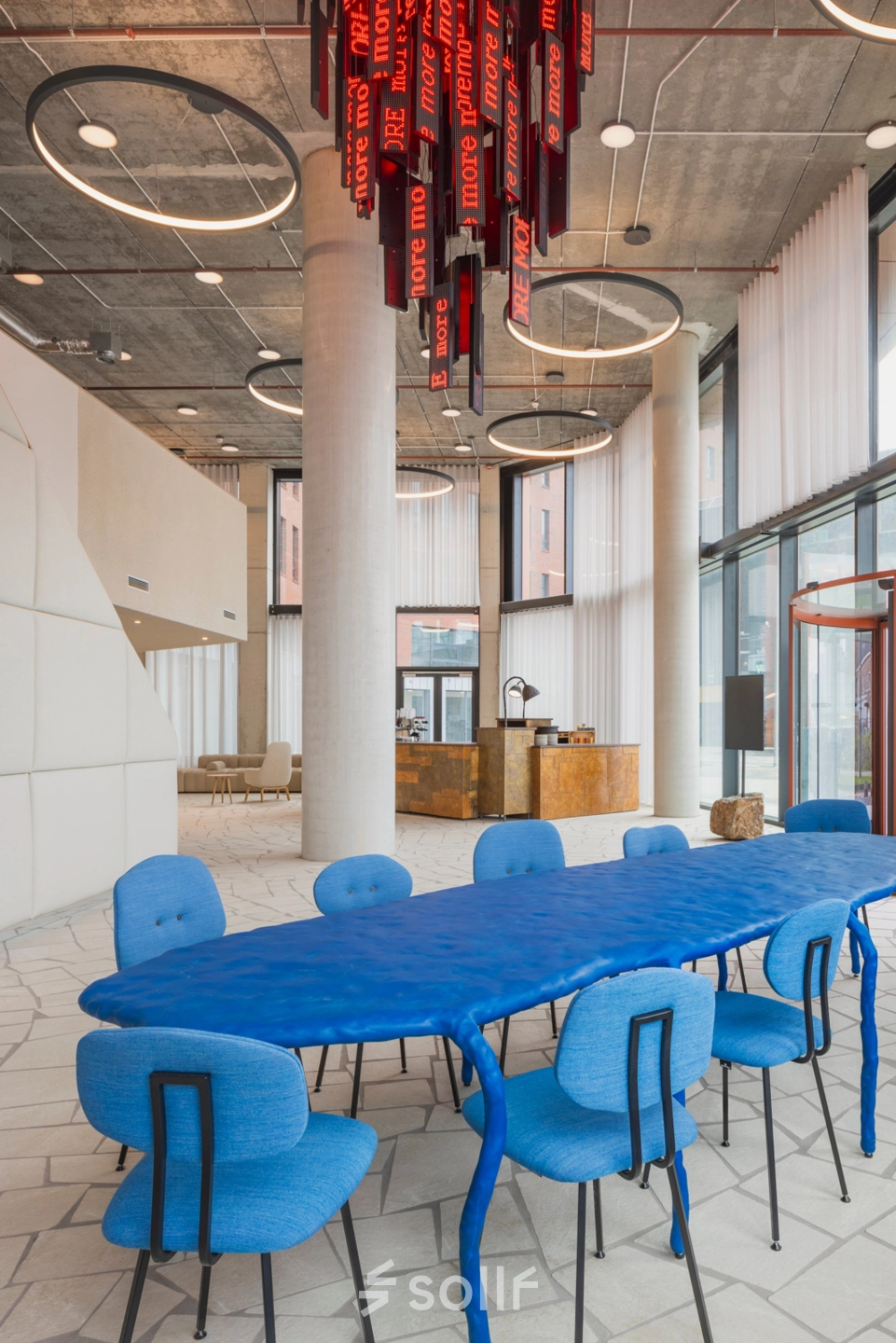 Moderne kantoorpand gelegen op H.J.E. Wenckebachweg 230-258 in Amsterdam Amstel Business Park, met opvallende blauwe vergadertafel en design verlichting.