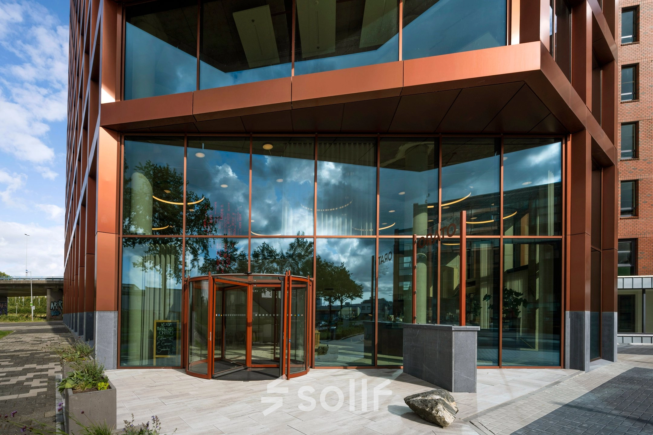 Glazen entree van het kantoorpand op H.J.E. Wenckebachweg 230-258 in Amsterdam Amstel Business Park, met een opvallend modern design ideaal voor kantoorruimte huren.