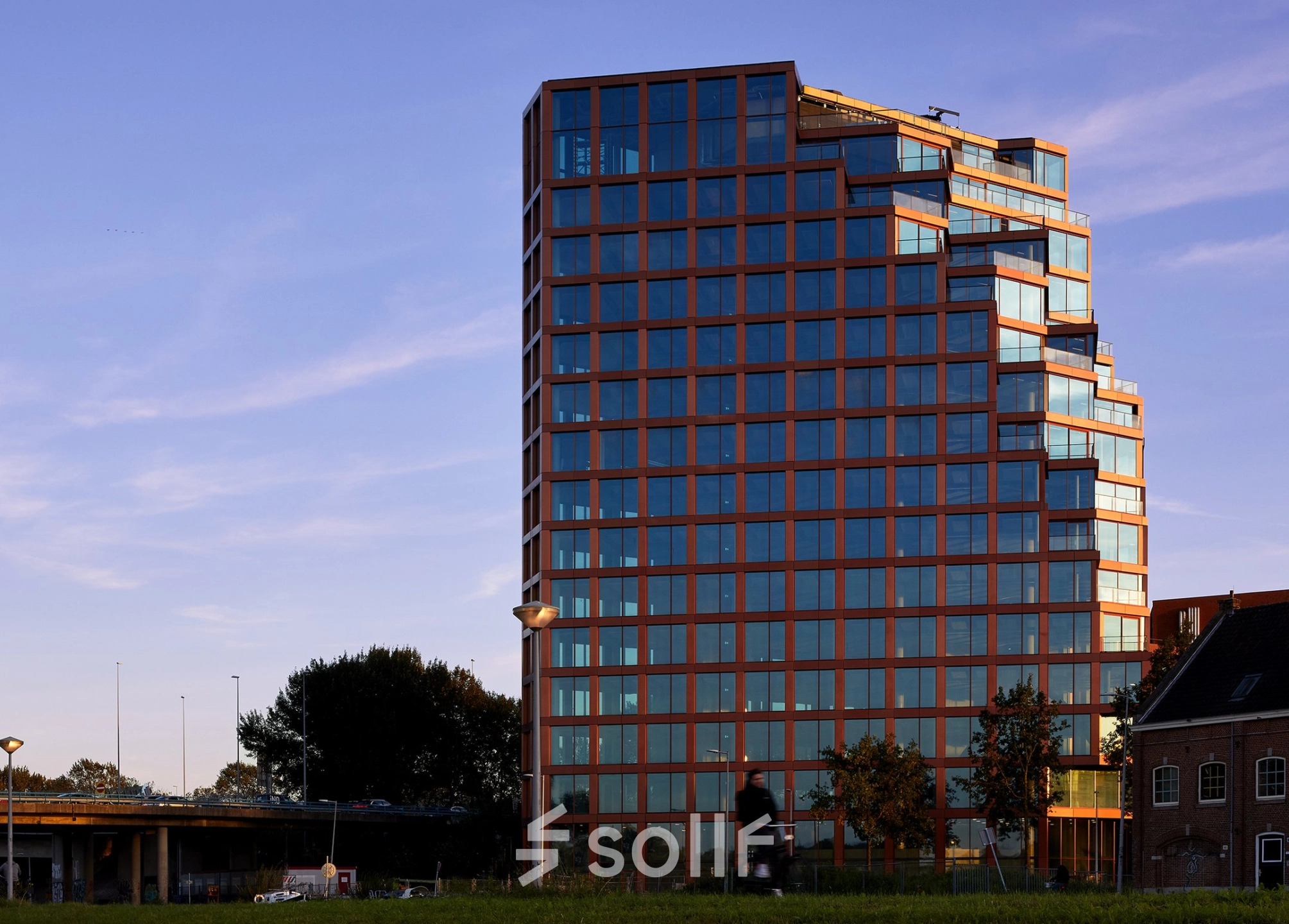 Modern kantoorpand gelegen aan de H.J.E. Wenckebachweg 230-258 in Amsterdam Amstel Business Park, omringd door groen en bereikbaar via nabijgelegen wegen. Ideaal voor bedrijven die kantoorruimte willen huren.