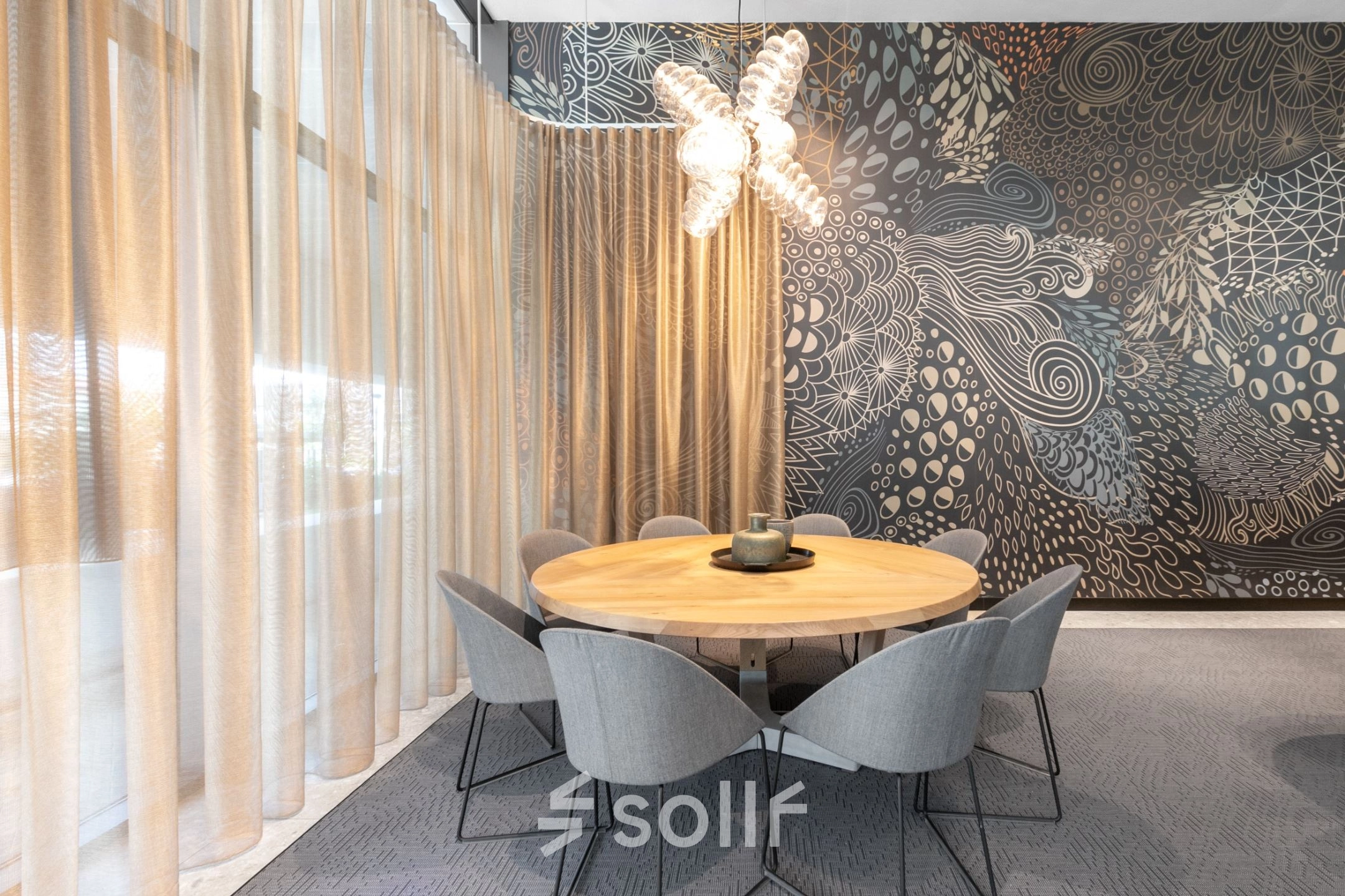 Moderne vergaderruimte in het kantoorpand op Trompenburgstraat 2c, Amsterdam Amstel Business Park, met een stijlvol ingerichte tafel en stoelen, omringd door artistieke muren en veel natuurlijk licht, ideaal om kantoorruimte te huren.