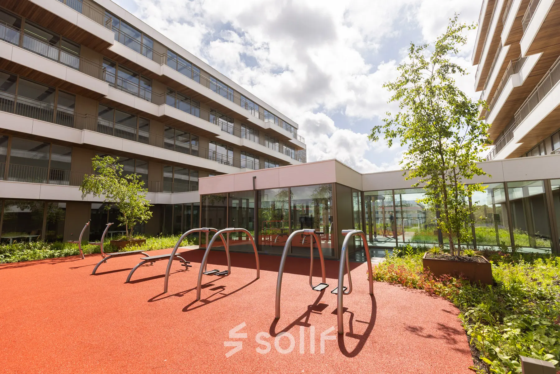 Moderne buitenruimte van kantoorpand aan Willem Fenengastraat 16, Amsterdam Amstel, met fietsenrekken en groene beplanting.