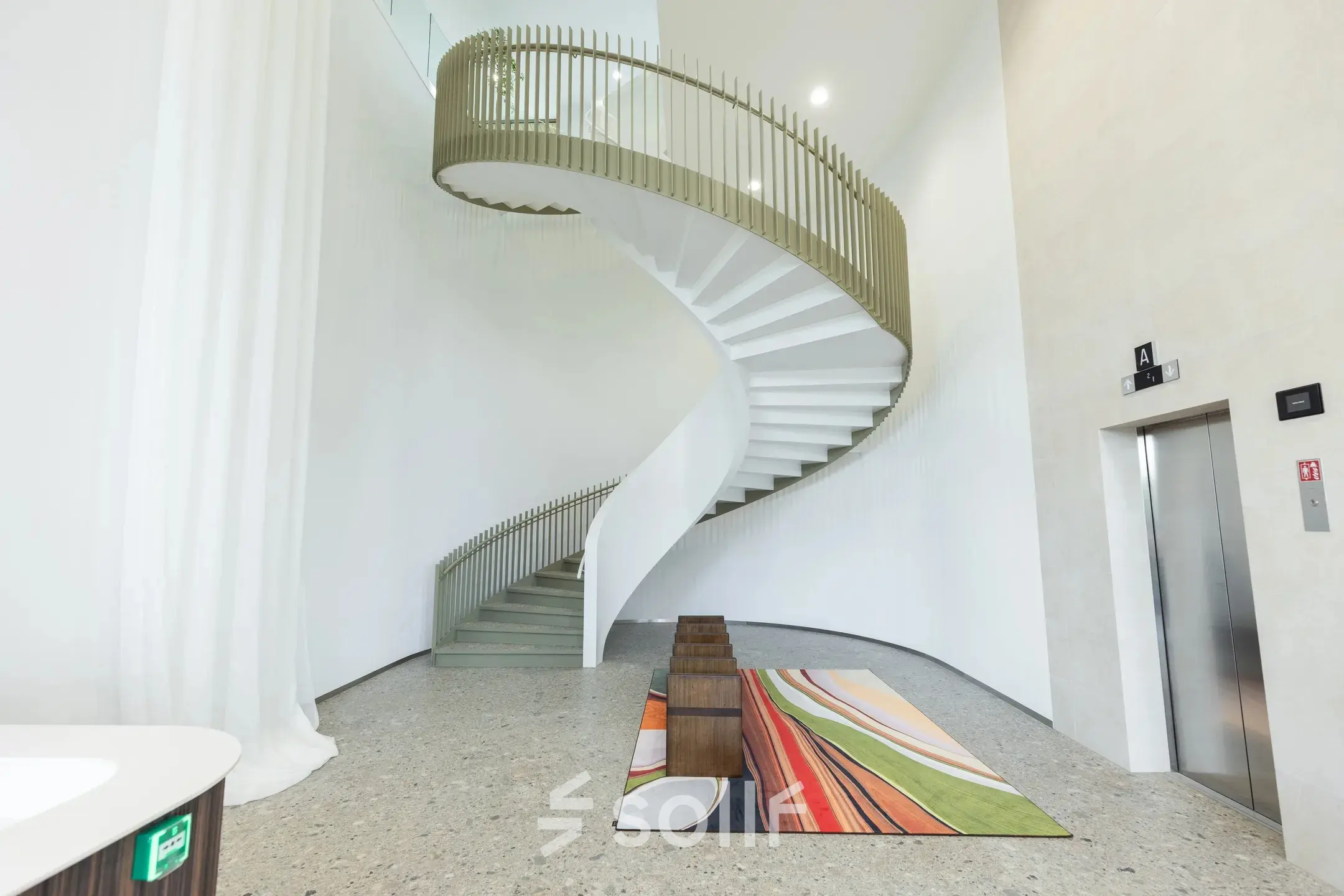 Kantoorpand in Amsterdam Amstel met moderne, gewelfde trappen en speels gekleurde vloerbedekking. Geschikt voor kantoorruimte huren op Willem Fenengastraat 16.