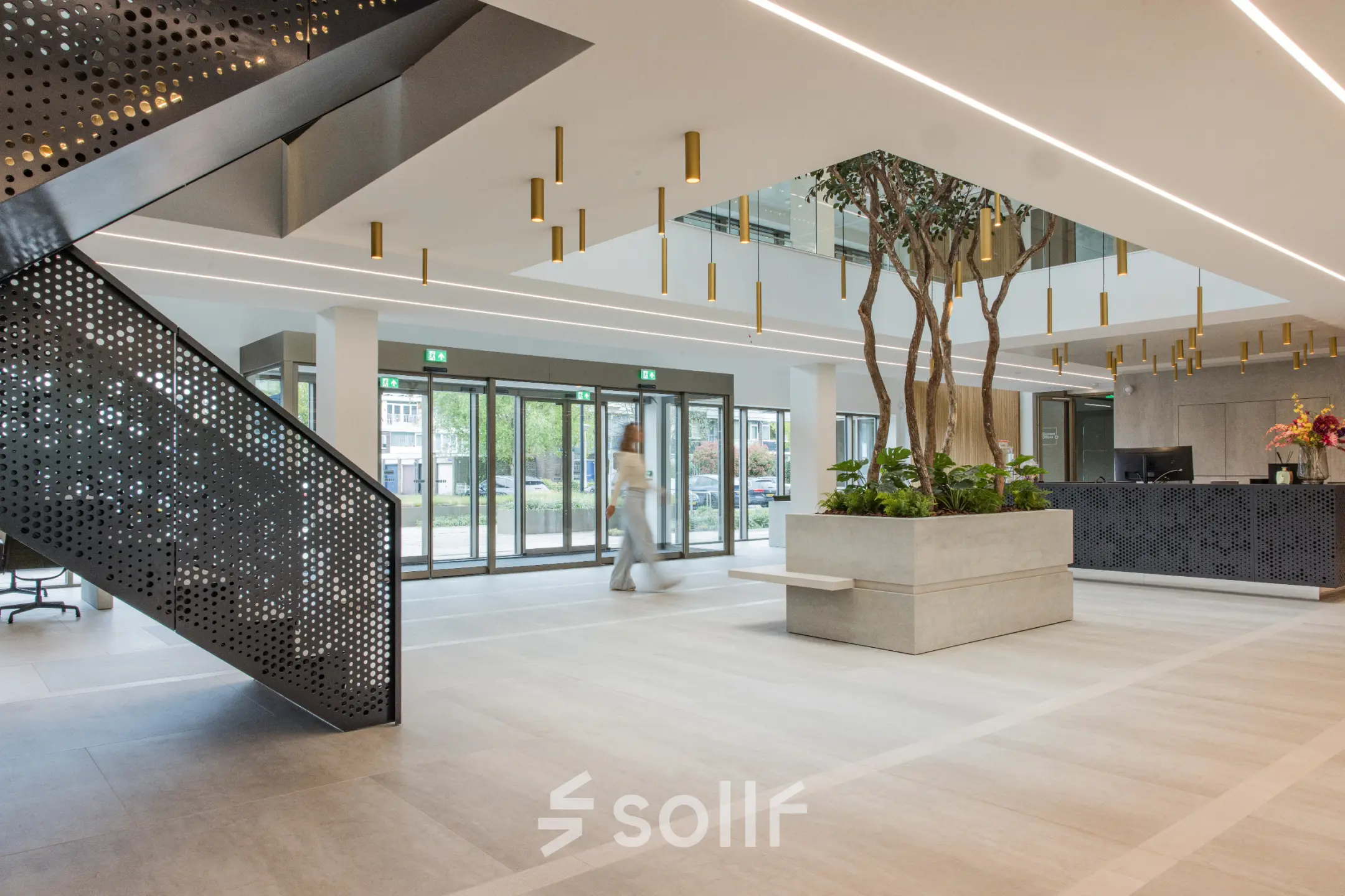 Moderne kantoorruimte te huur op Walborg 2A in Amsterdam Buitenveldert, met een stijlvolle entree, plantenbakken en een geometrisch vormgegeven trap. Ideale plek voor je volgende kantoorpand.