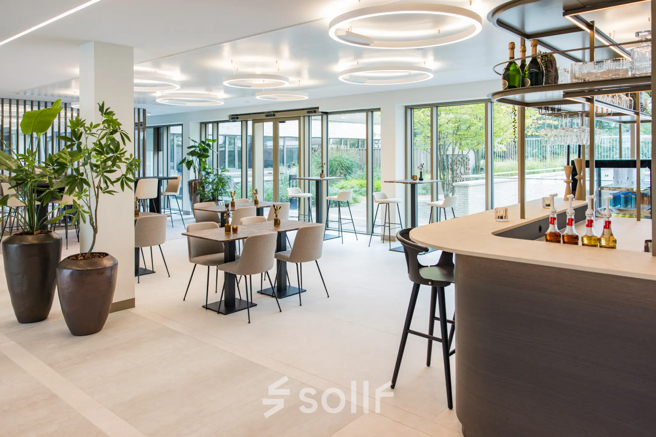 Moderne kantoorpand lounge in Amsterdam Buitenveldert aan Walborg 2A met ruime zitjes, hoge tafels en grote ramen. Ideaal voor informeel overleg of ontspanning na het huren van kantoorruimte.