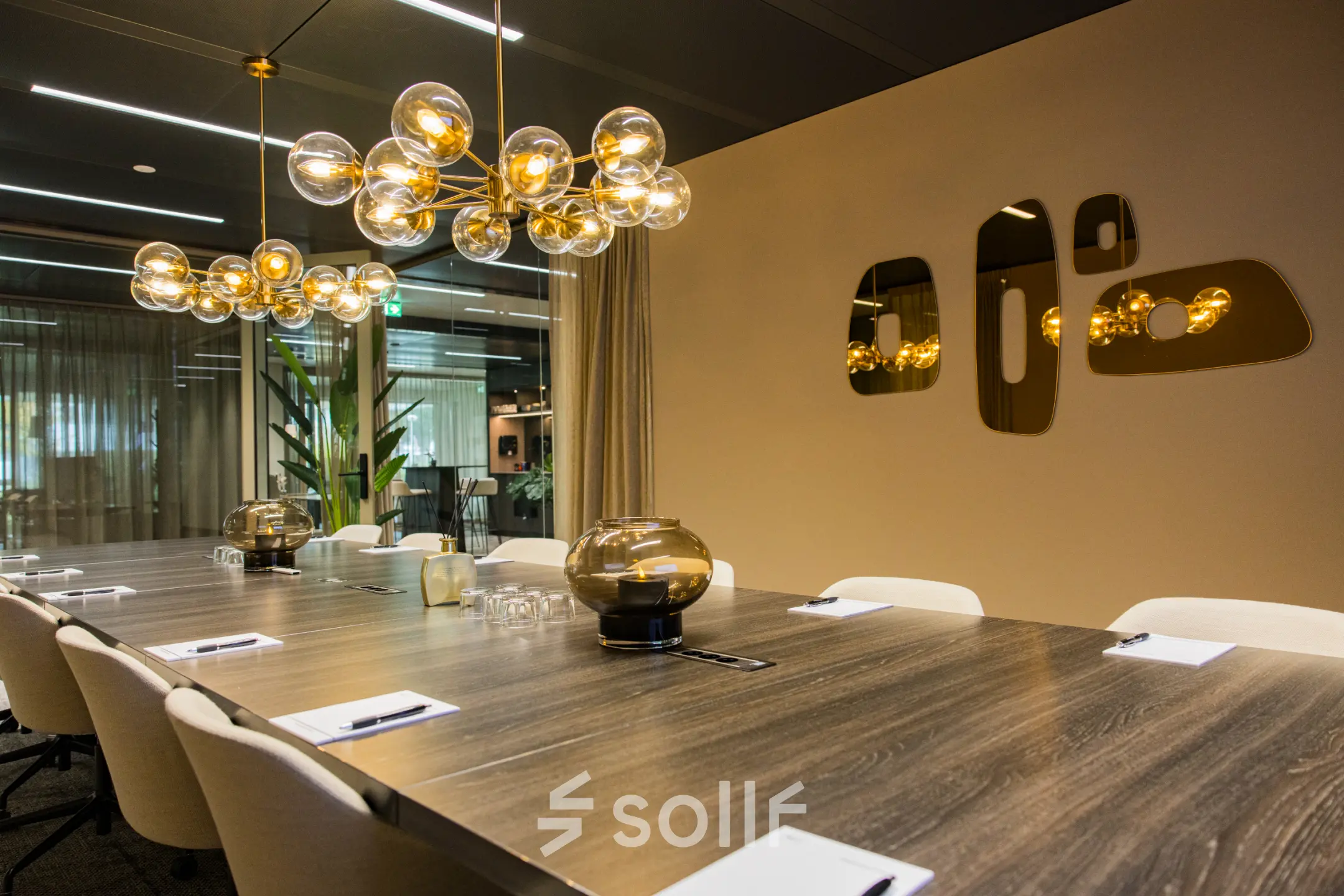 Stijlvolle vergaderruimte in Amsterdam Buitenveldert met lange houten tafel, moderne stoelen en opvallende verlichting, ideaal voor kantoorruimte huren.