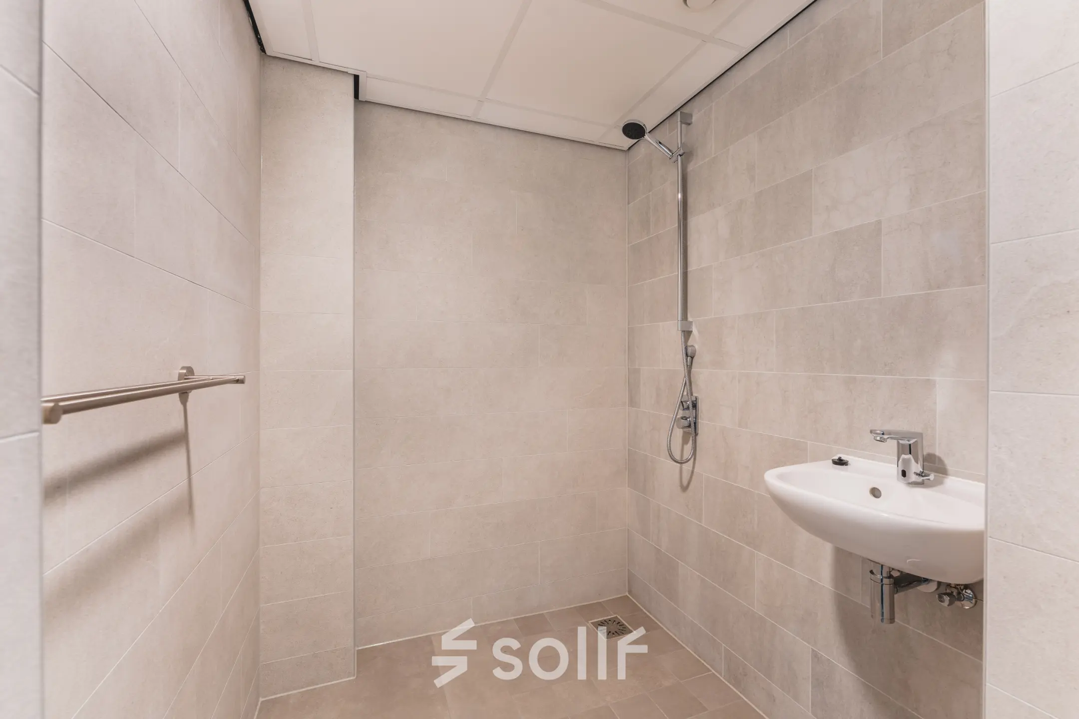 Een moderne badkamer in het kantoorpand op Walborg 2A, Amsterdam Buitenveldert. De ruimte heeft een douche en een wastafel en kan nuttig zijn voor medewerkers tijdens werkuren. Een ideale toevoeging bij het huren van kantoorruimte.