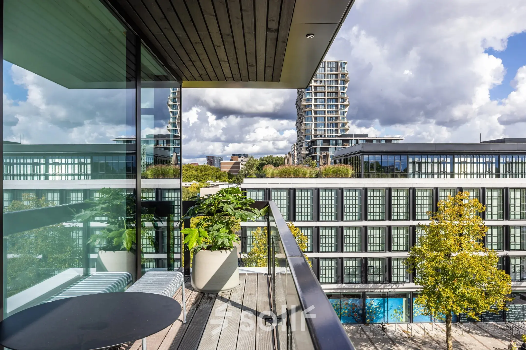 Uitzicht vanaf een balkon in Amsterdam Buitenveldert met moderne kantoorgebouwen op de achtergrond, ideaal voor kantoorruimte huren.