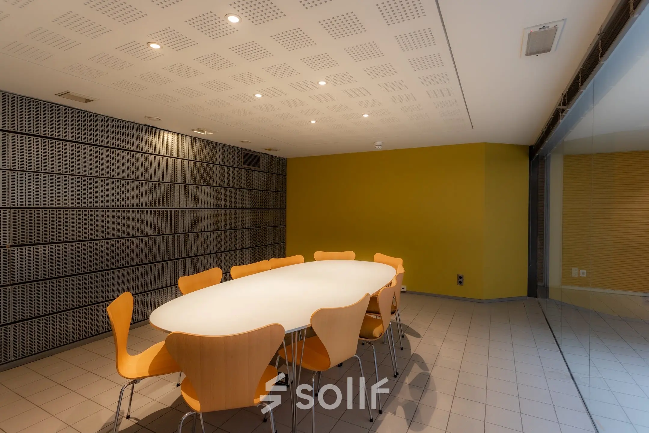 Vergaderruimte in kantoor aan Kerkstraat 204, Amsterdam Centrum, met lange tafel en acht houten stoelen.